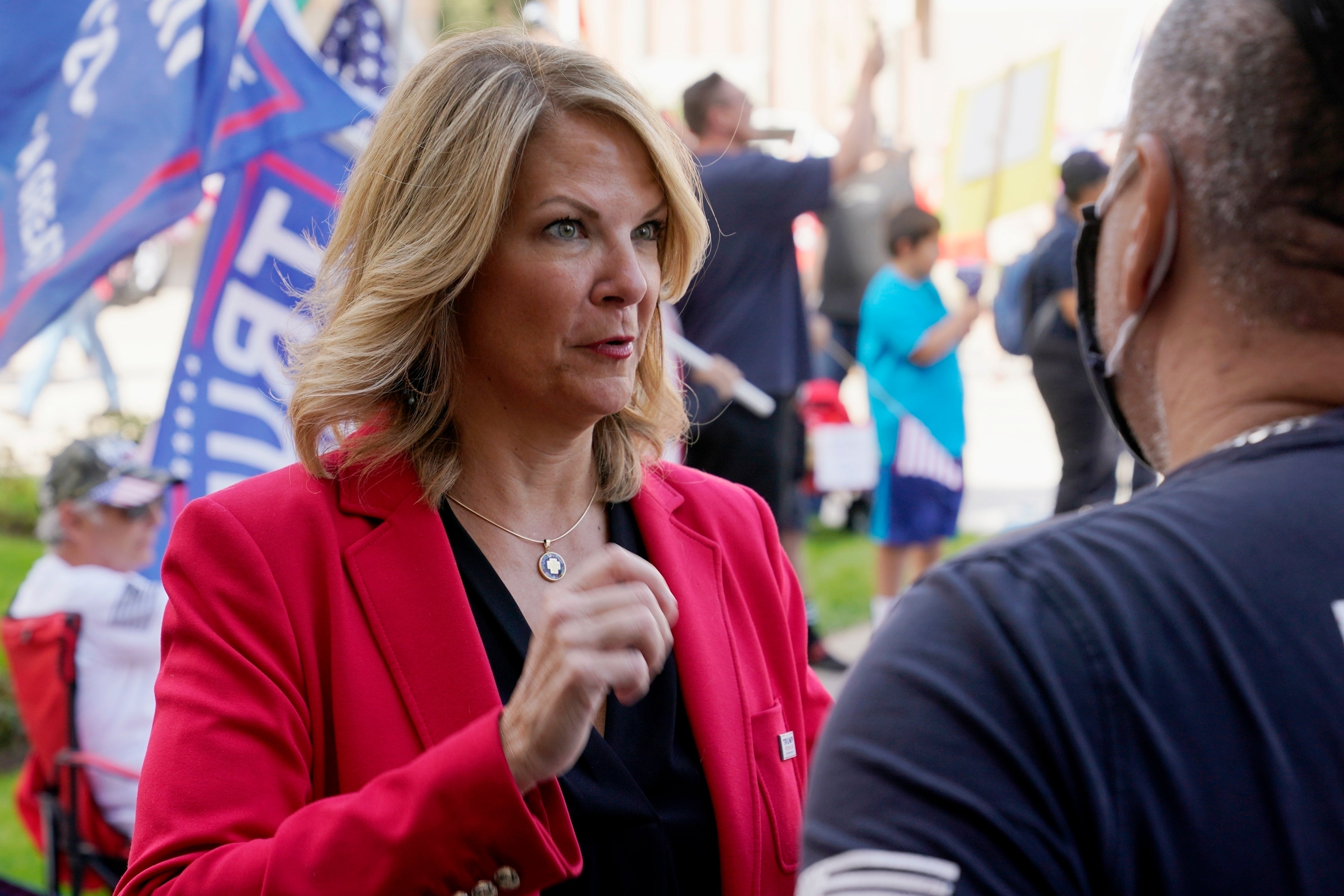 Dr. Kelli Ward, left, chair of the Arizona Republican Party, talks with a supporter of President Donald Trump as they join the crowd at a rally outside the Arizona Capitol, Nov. 7, 2020
