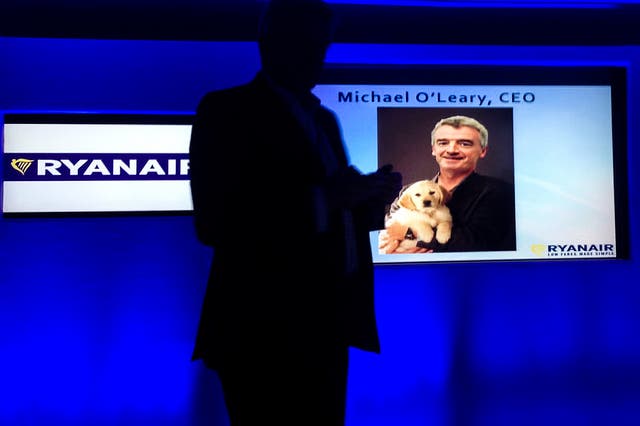 <p>Michael O’Leary, in silhouette, at a 2014 press conference promoting a softer image for Ryanair – complete with a photo of him cuddling a puppy </p>