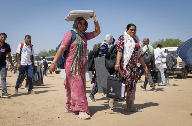 <p>An Indian polling officer carries an Electronic Voting Machine</p>
