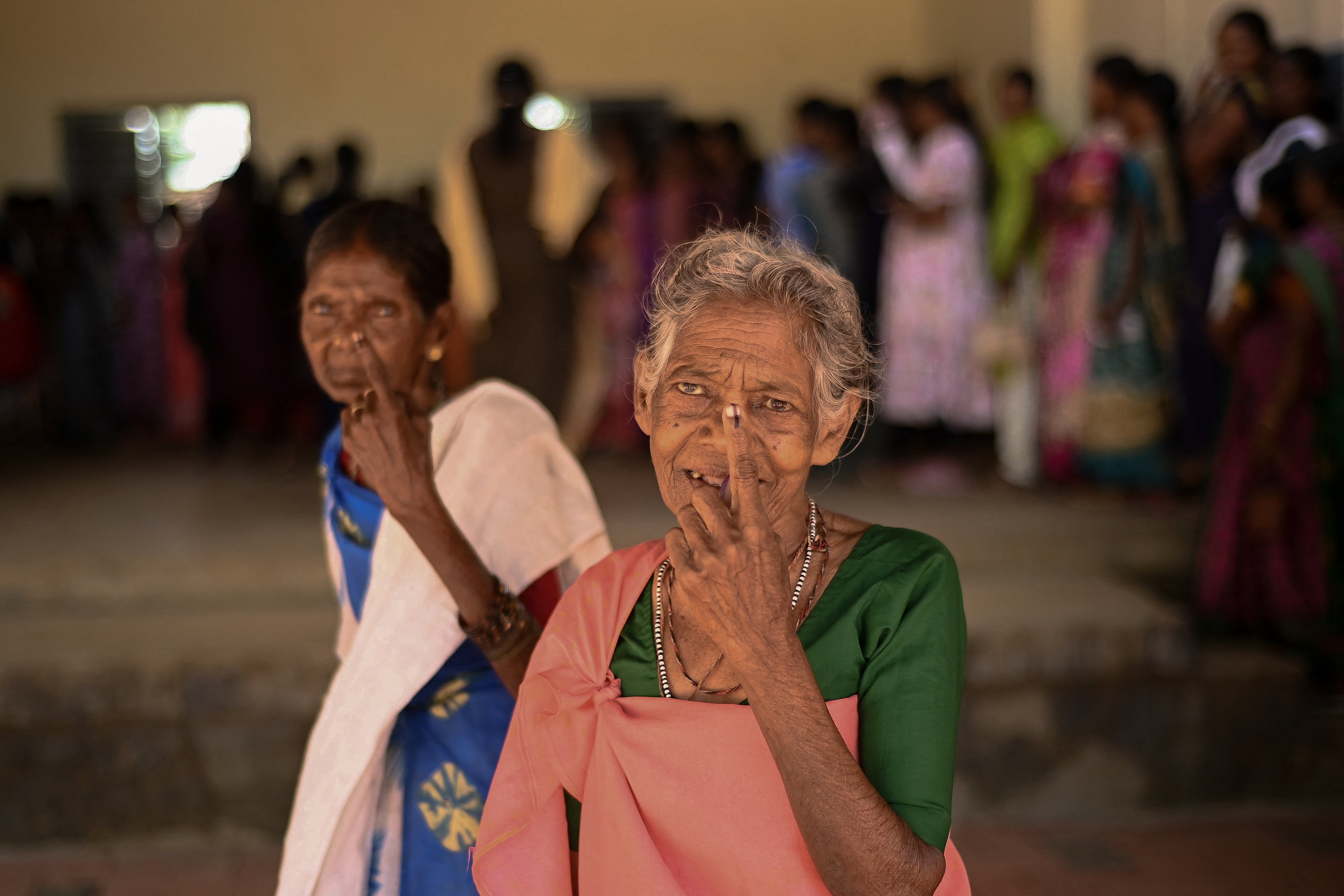 Tribal people display inked fingers after voting in the Wayanad district in the southern state of Kerala