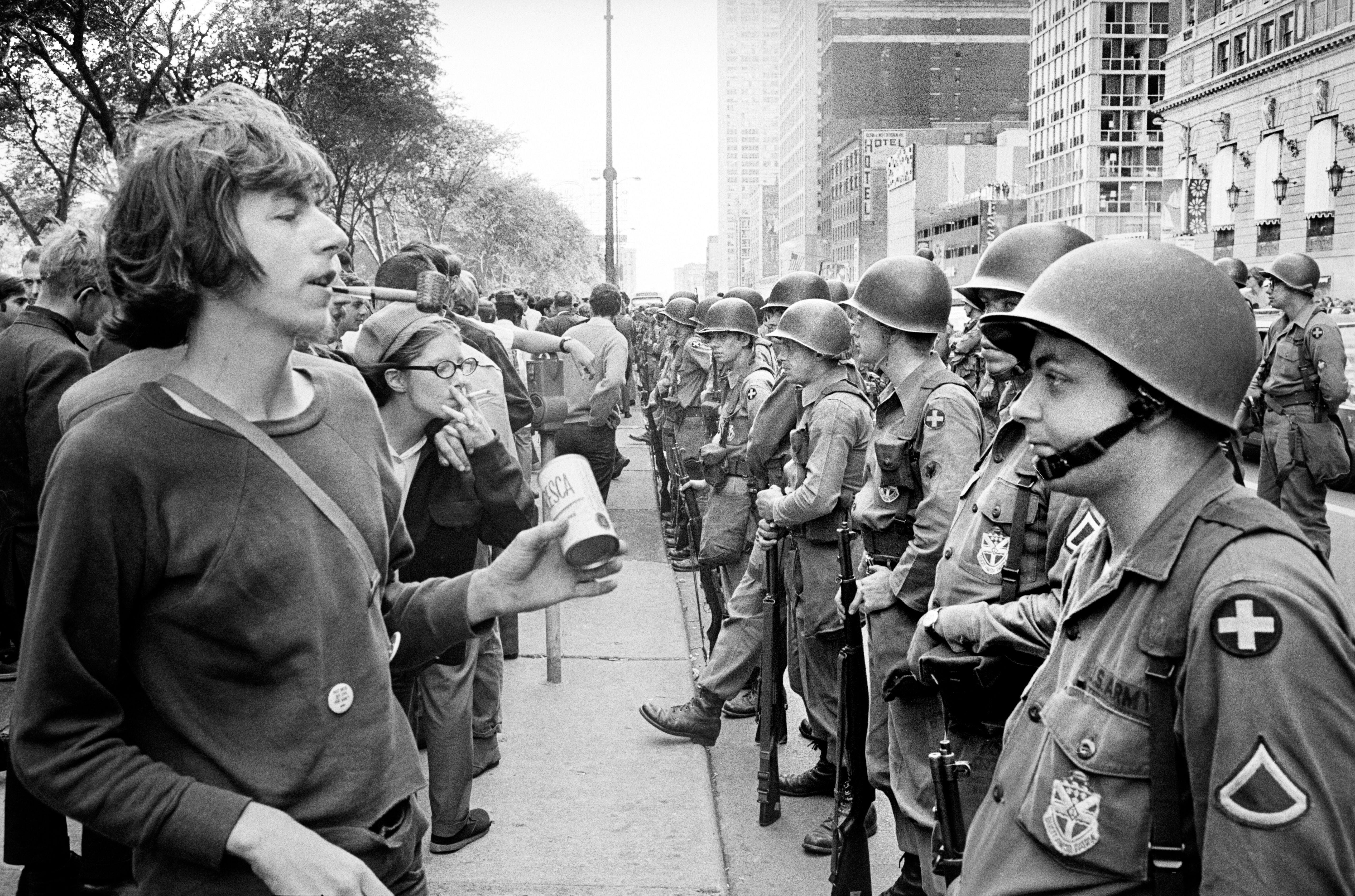 People standing in front of a row of National Guard soldiers, across from the Hilton Hotel at Grant Park during the Democratic National Convention, Chicago, Illinois, on August 26, 1968