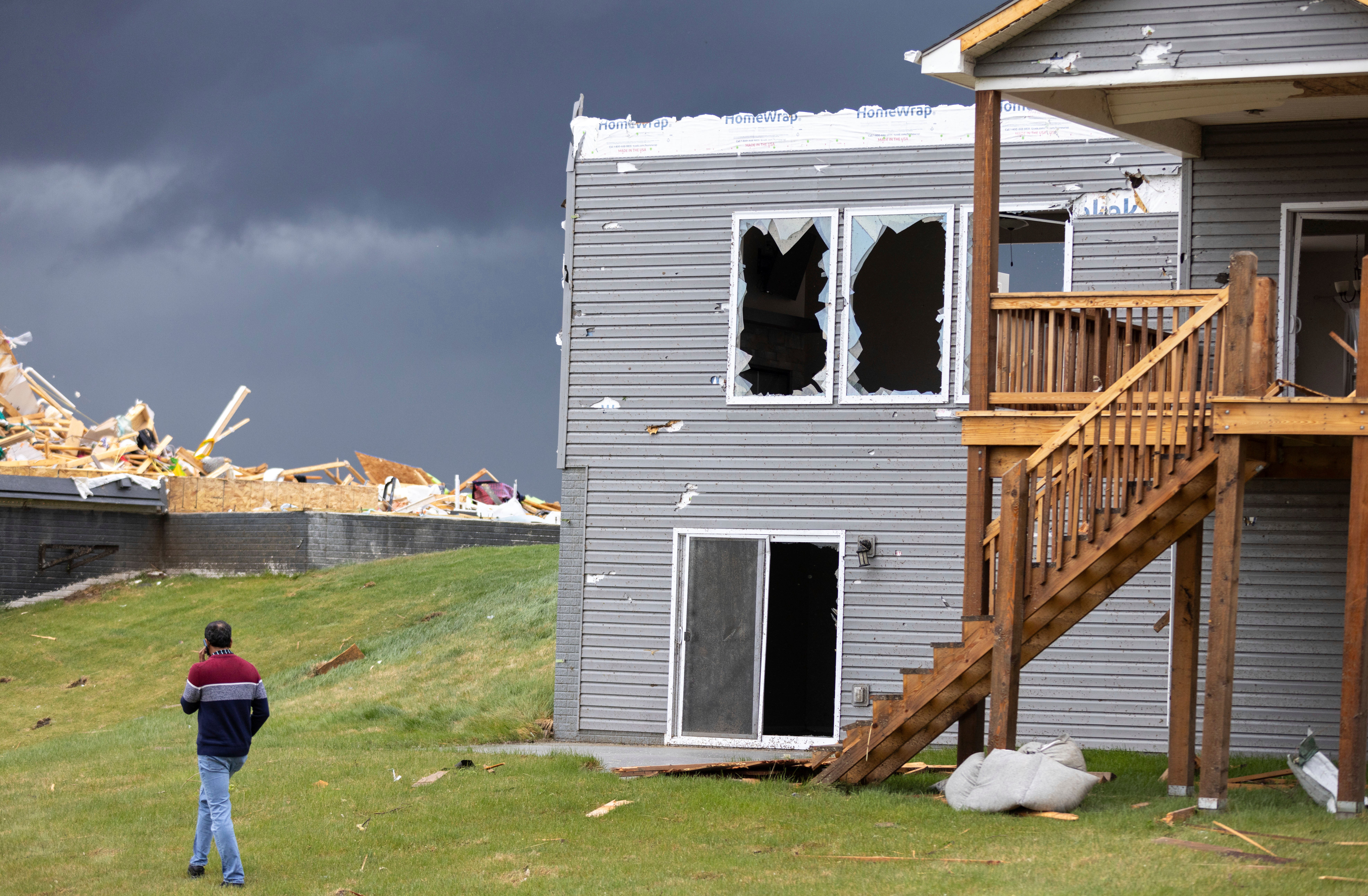Gopala Penmetsa walks past a damaged house after a tornado passed through the area near Omaha, Nebraska on 26 April