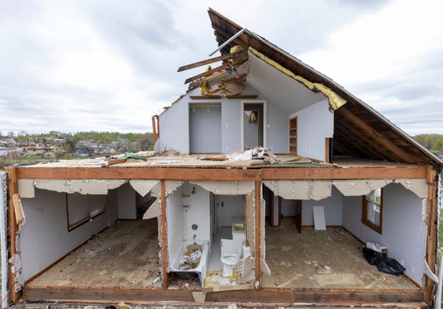 <p>A partially torn off roof is seen on a damaged home in Omaha on 27 April </p>