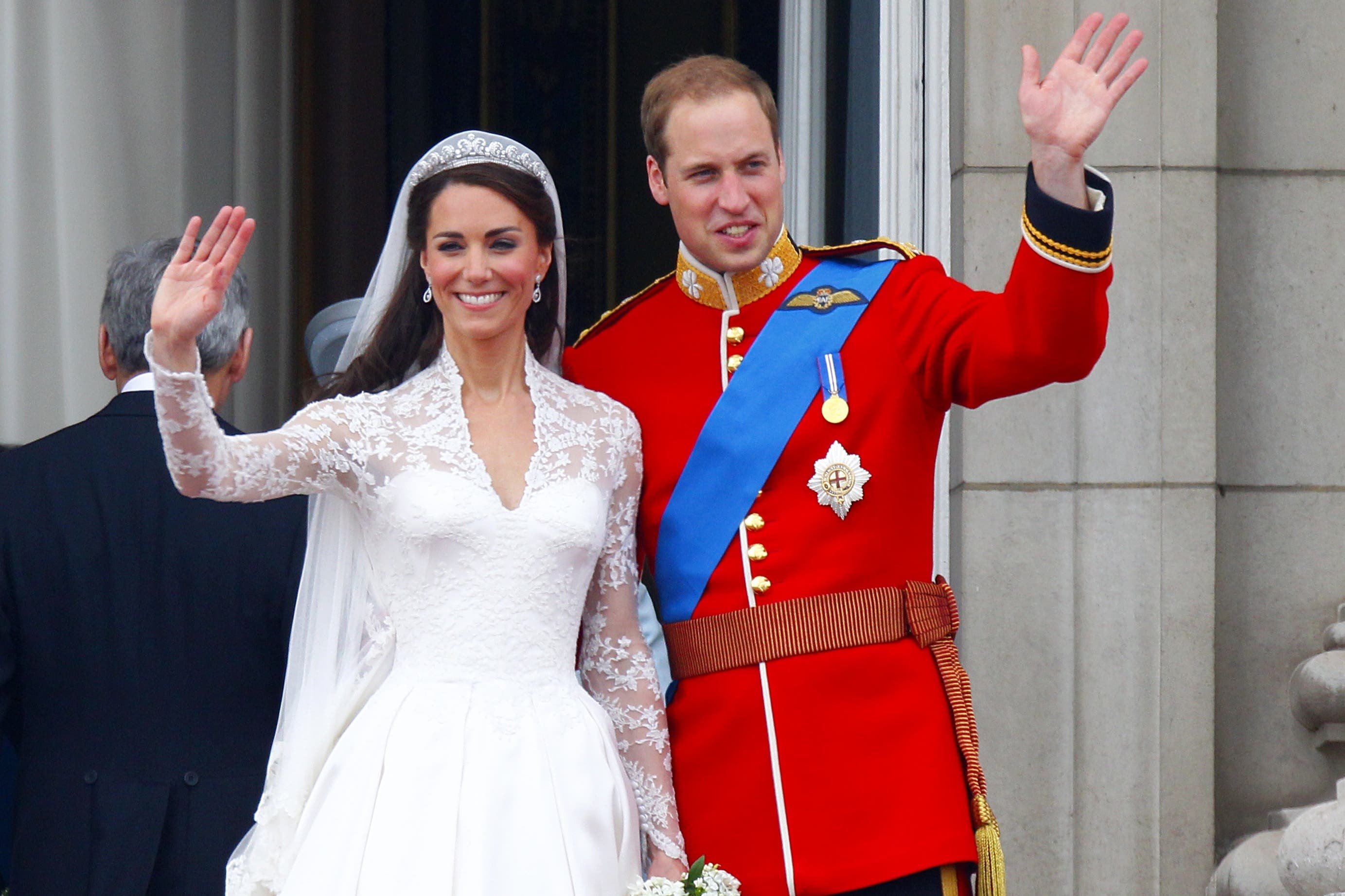 Prince William and his wife Kate wave to the crowds from the balcony of Buckingham Palace following their wedding at Westminster Abbey