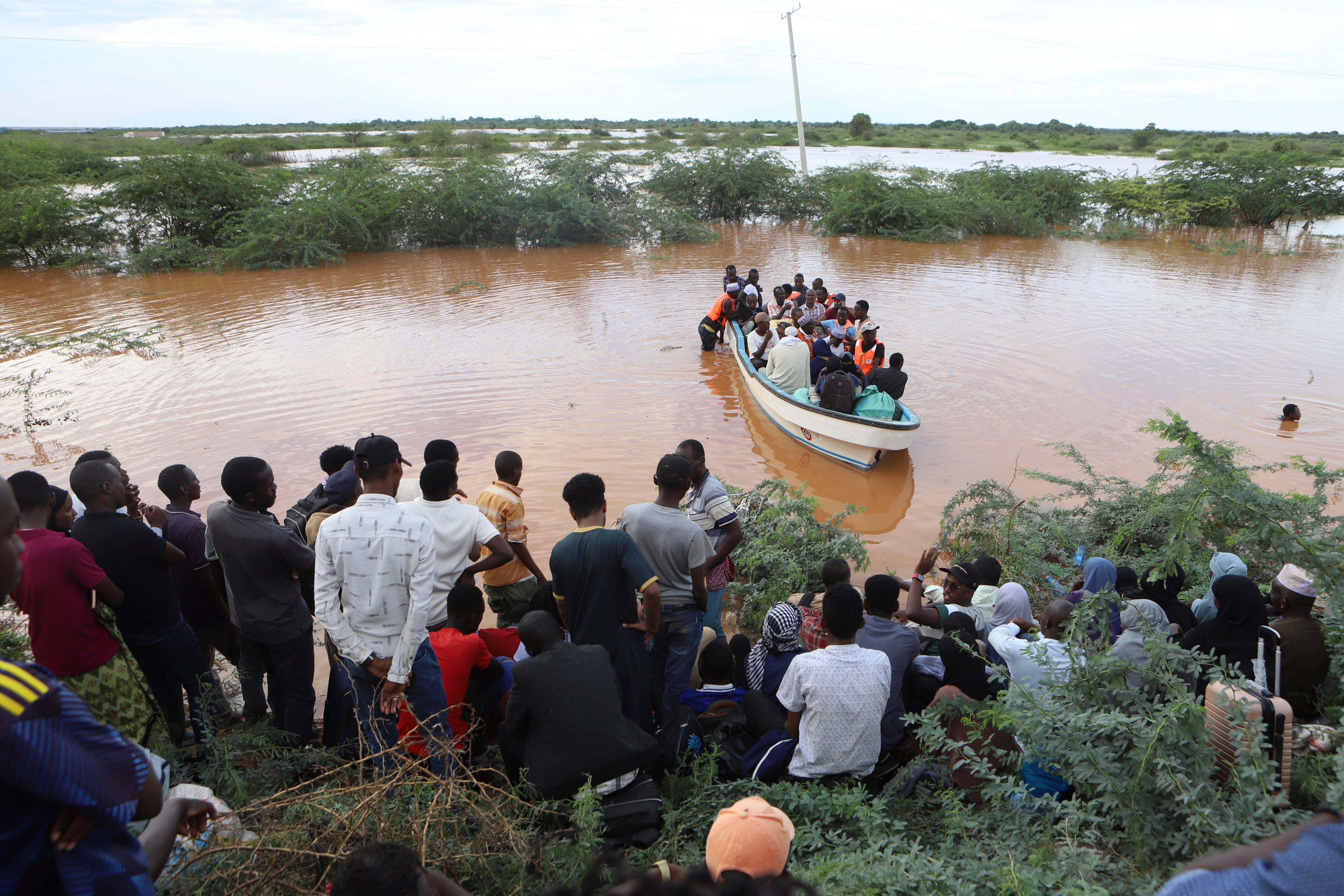 People cross a flooded area at Mororo, border of Tana River and Garissa counties, North Eastern Kenya