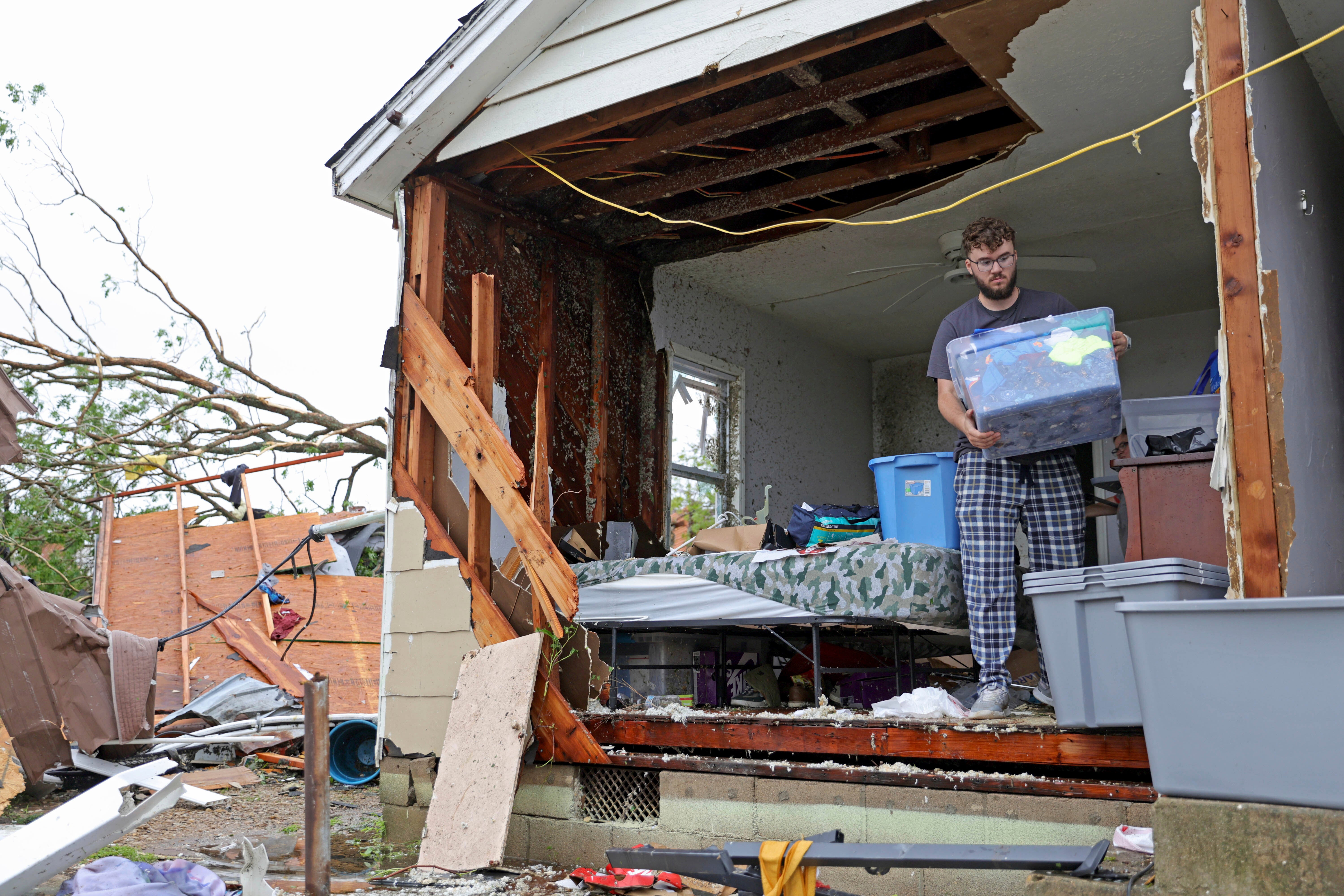 A man moves salvaged items from a destroyed home in Sulphur, Oklahoma on Sunday. At least 100 people statewide sustained injuries from the tornadoes