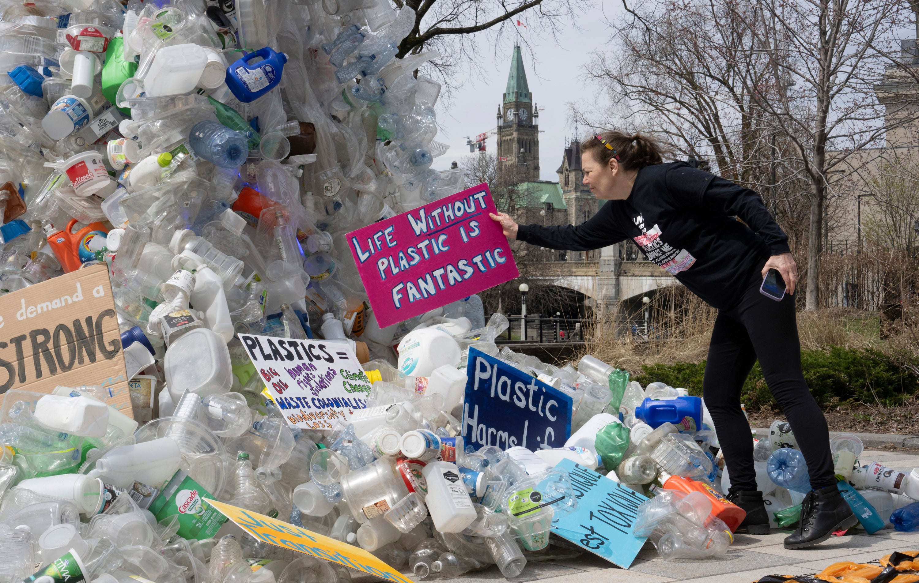 Activist Dianne Peterson places a sign on an art installation outside a United Nations conference on plastics in April in Ottawa, Ontario