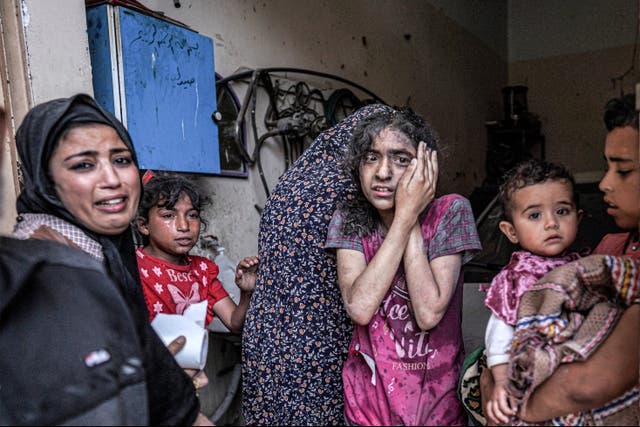 <p>A woman and children react after an Israeli bombardment of Nuseirat in the central Gaza Strip</p>