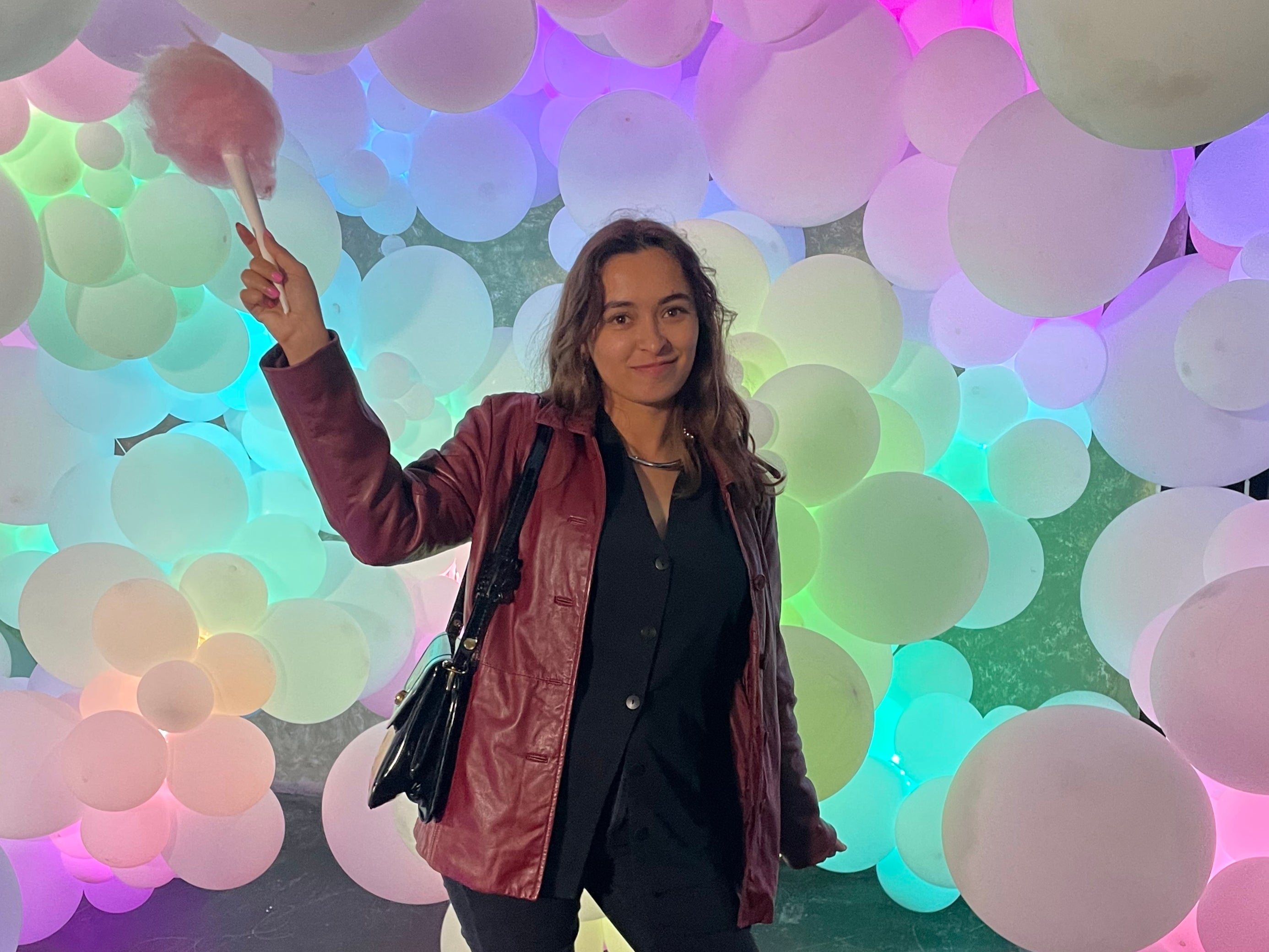 Olivia Hebert posing with cotton candy in front of Molly Balloons’ balloon art installation at the Willy Wonka Experience in Downtown Los Angeles, California on 28 April.