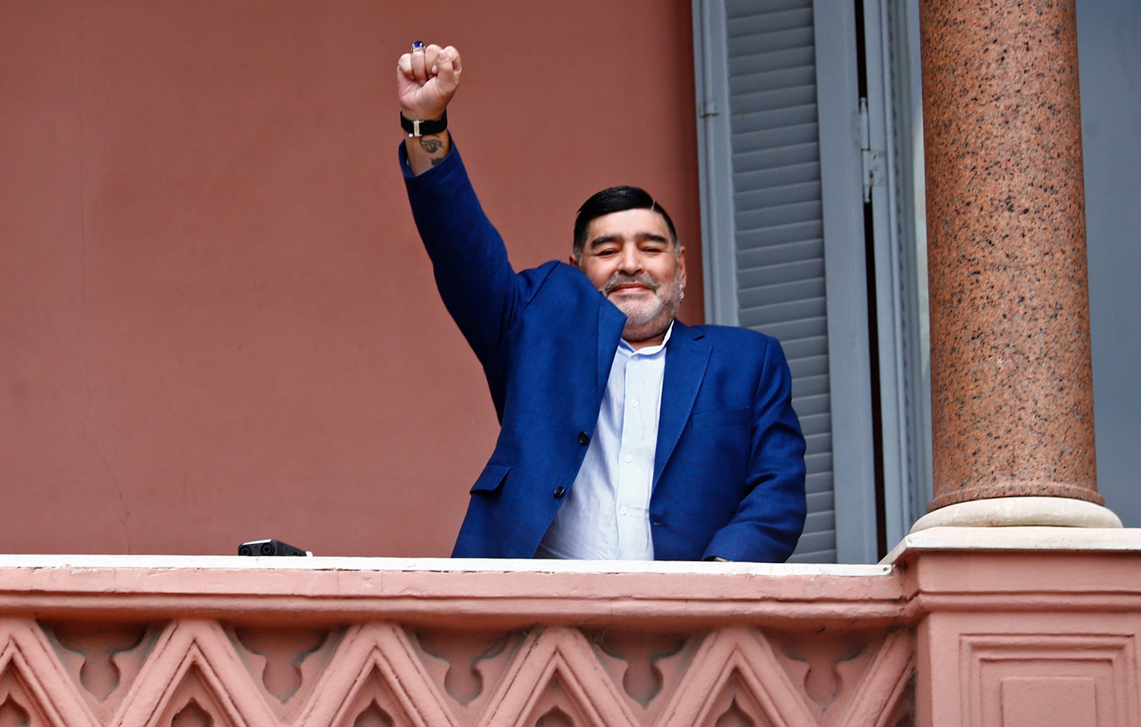 Former soccer great Diego Maradona acknowledges fans below at the Casa Rosada government house