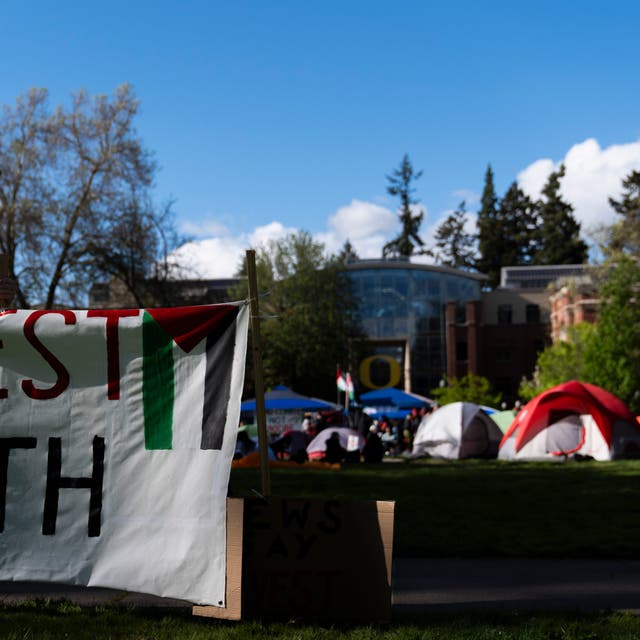 <p>A student at the University of Oregon sets up a sign that reads "Divest from death" as students set up a tent encampment at the university to protest the Israel-Hamas war on Monday, April 29, 2024</p>