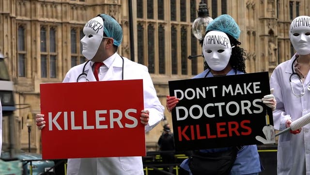 <p>Masked medics join anti-euthanasia protest outside parliament.</p>