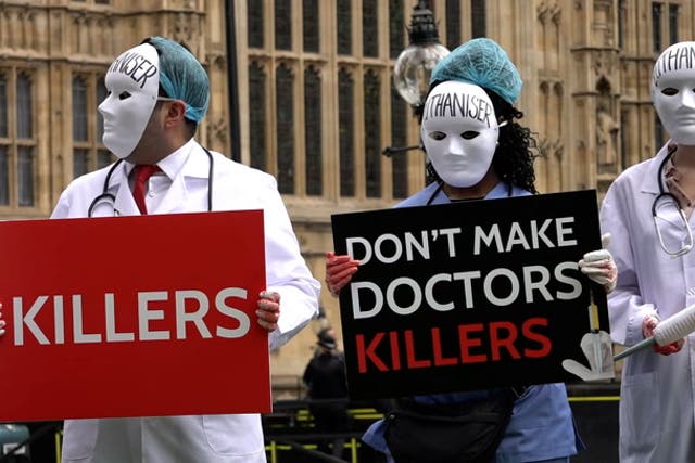<p>Masked medics join anti-euthanasia protest outside parliament.</p>