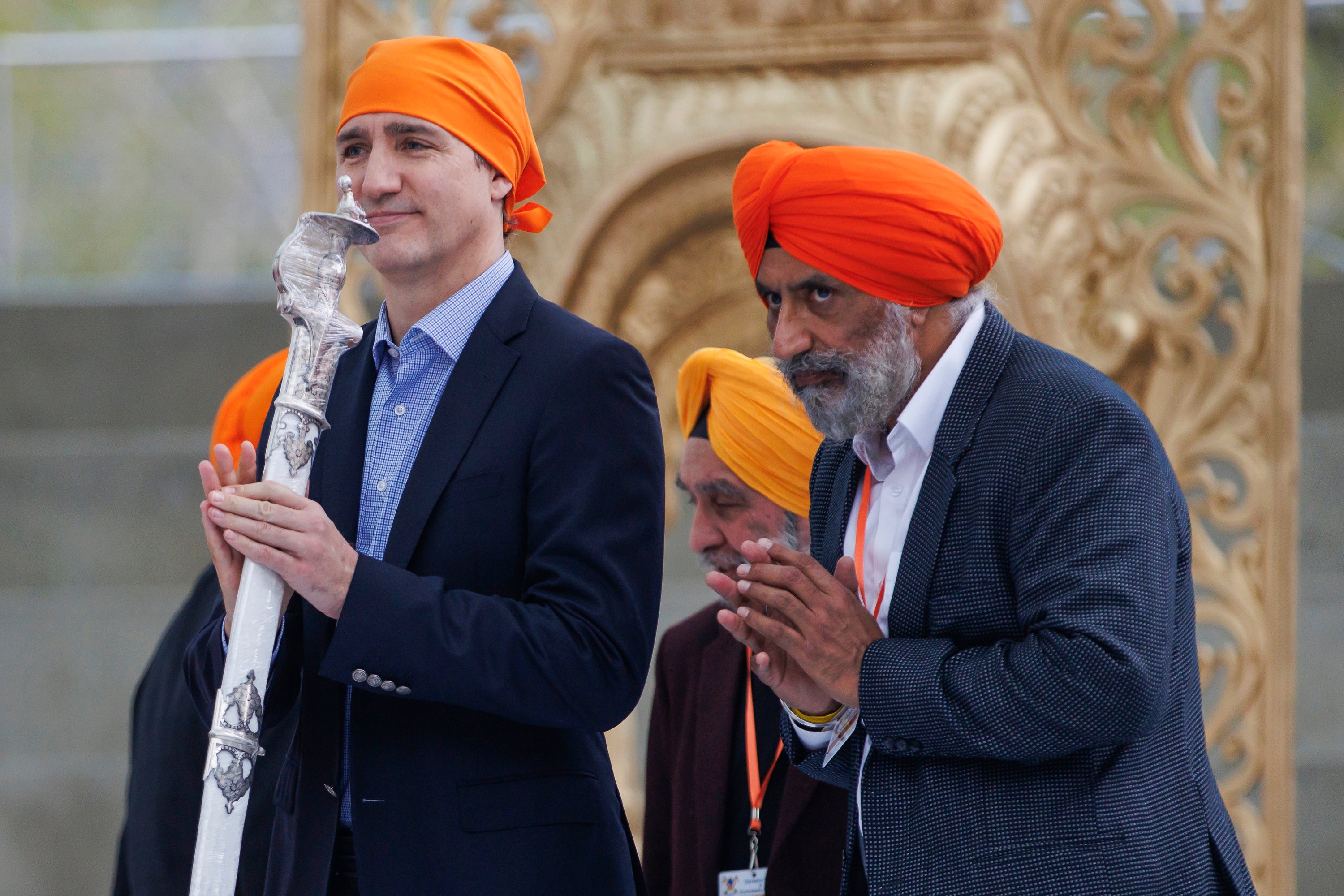 <p>Justin Trudeau reacts after receiving a ceremonial sword as a gift from Sikhs in Ontario</p>