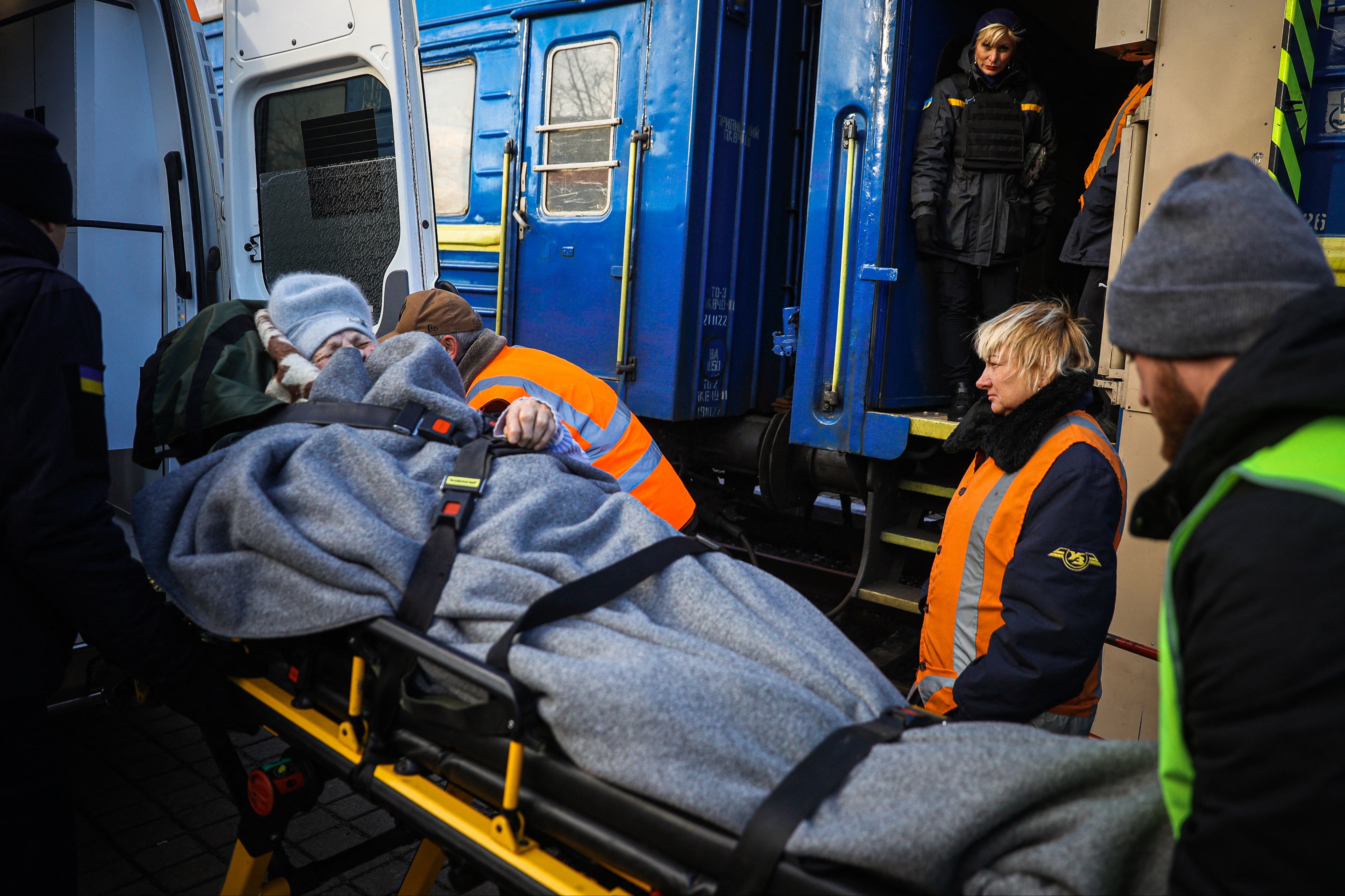 Members of the Vostok SOS team help a woman with limited mobility to get on an evacuation train in Pokrovsk, Donetsk region