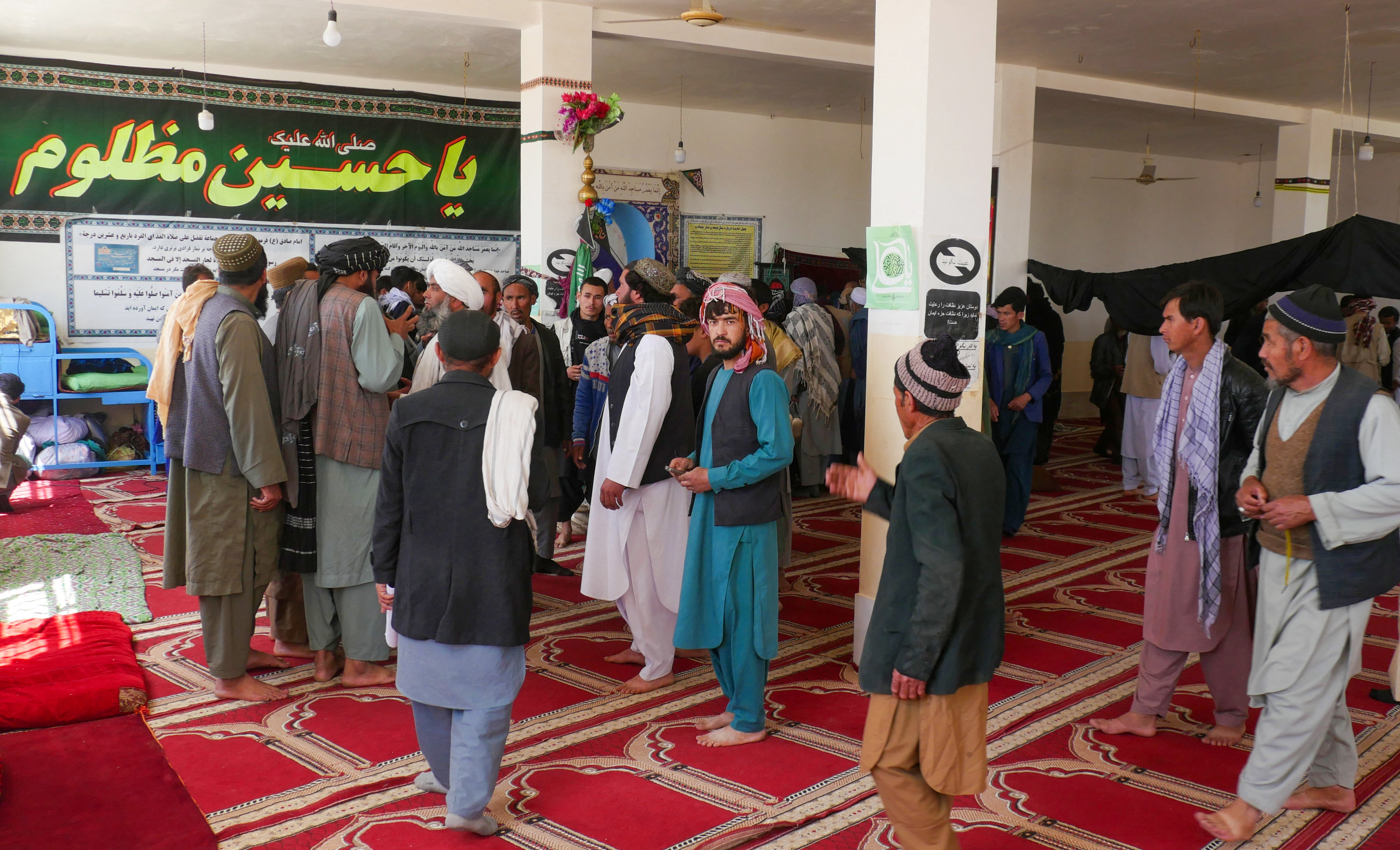 Afghans gather at a mosque where gunmen attacked Shiite Muslims in Guzara district of Herat province