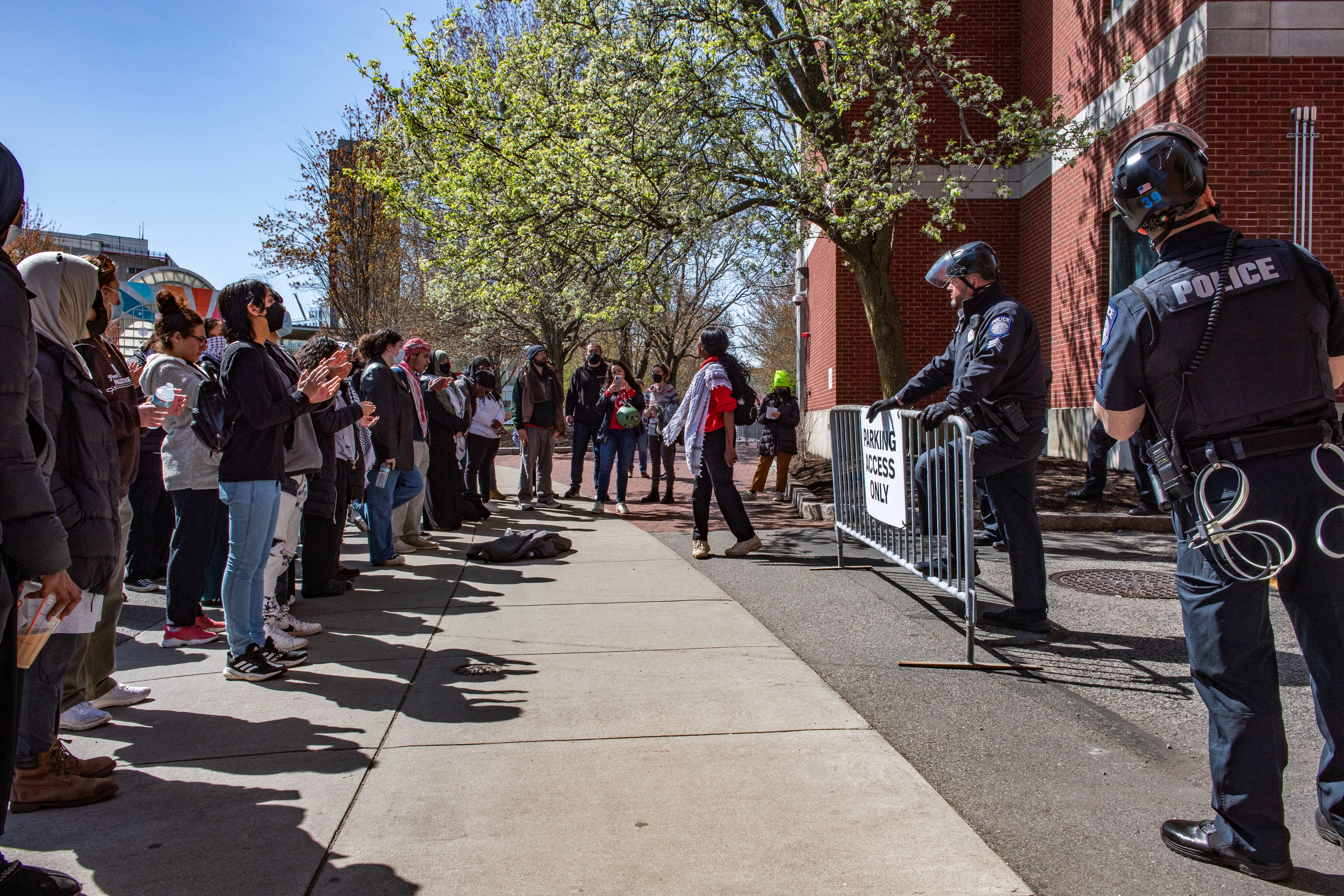 Pro-Palestinian protesters stand in front of a police barricade at Northeastern University on 27 April. Police arrested 29 students and six university employees