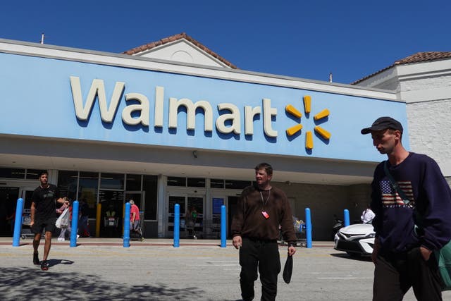 <p>People walk near the entrance to a Walmart Supercenter on February 20, 2024, in Hallandale Beach, Florida. </p>