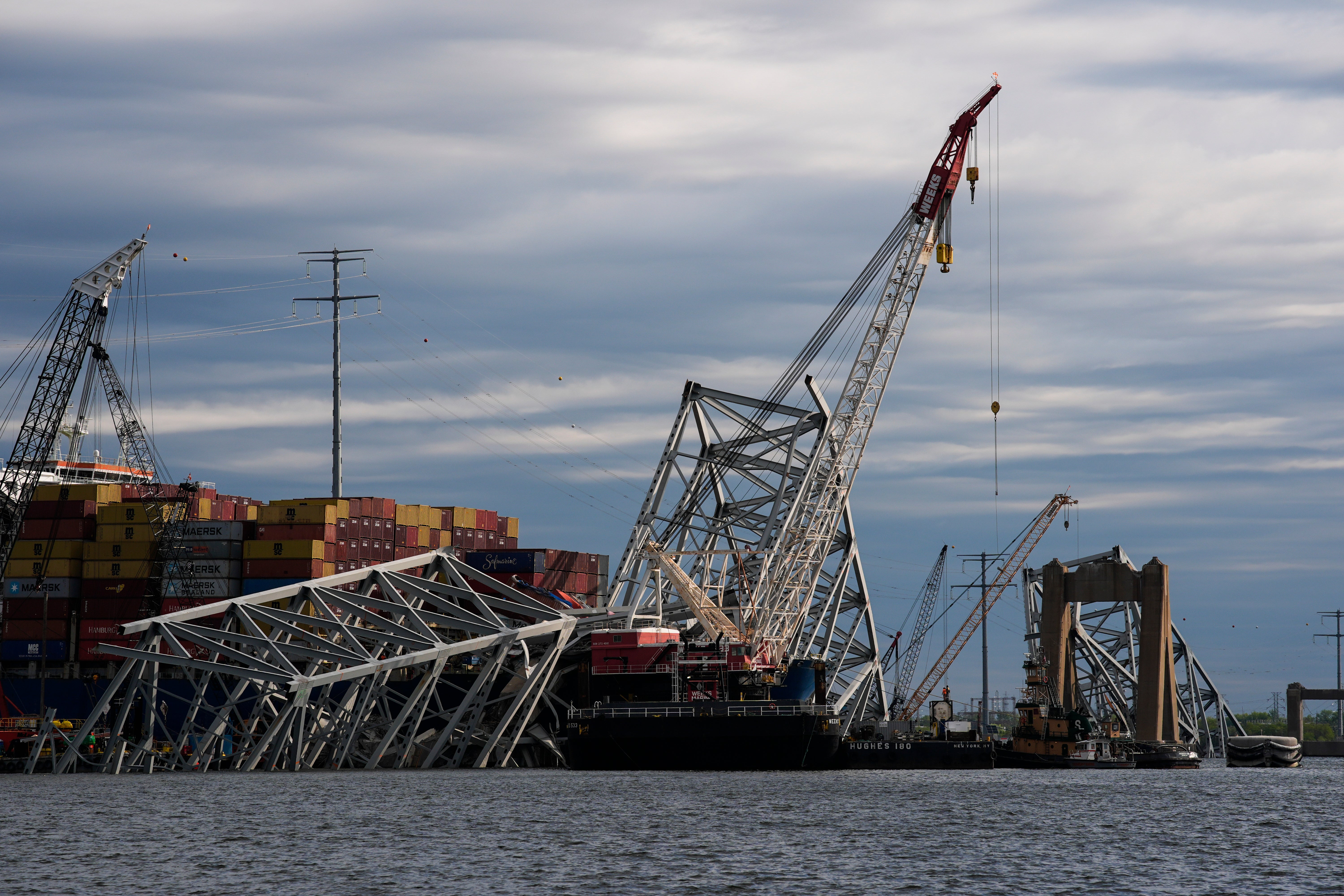The collapsed Francis Scott Key Bridge lays on top of the container ship Dali