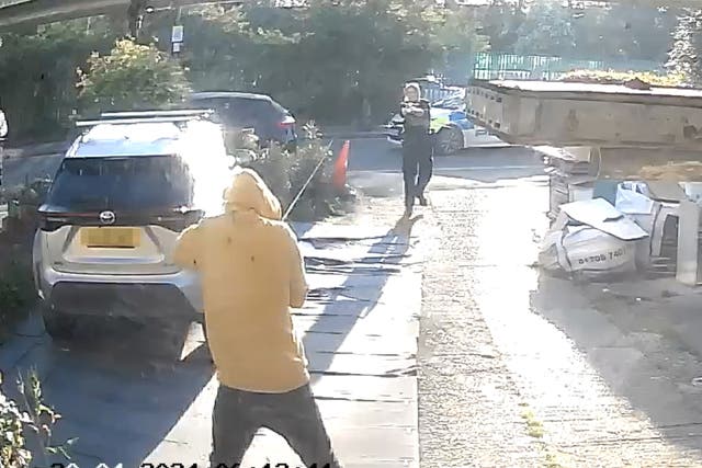 Handout footage from a doorbell camera of police officers tasering and detaining a sword-wielding man in Hainault, north-east London (PA)