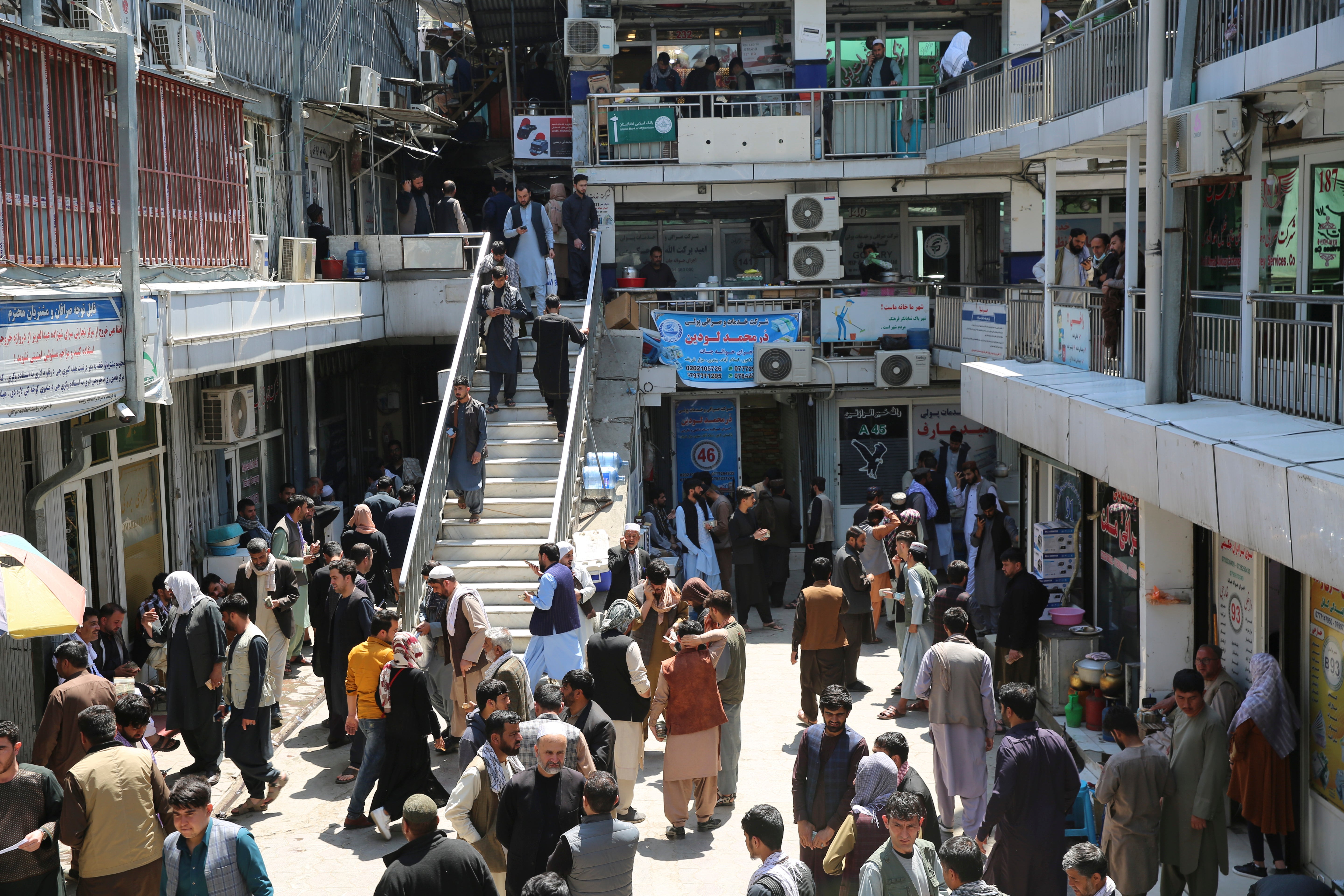Afghans walk around a downtown currency exchange market in Kabul, Afghanistan, Monday, April 22