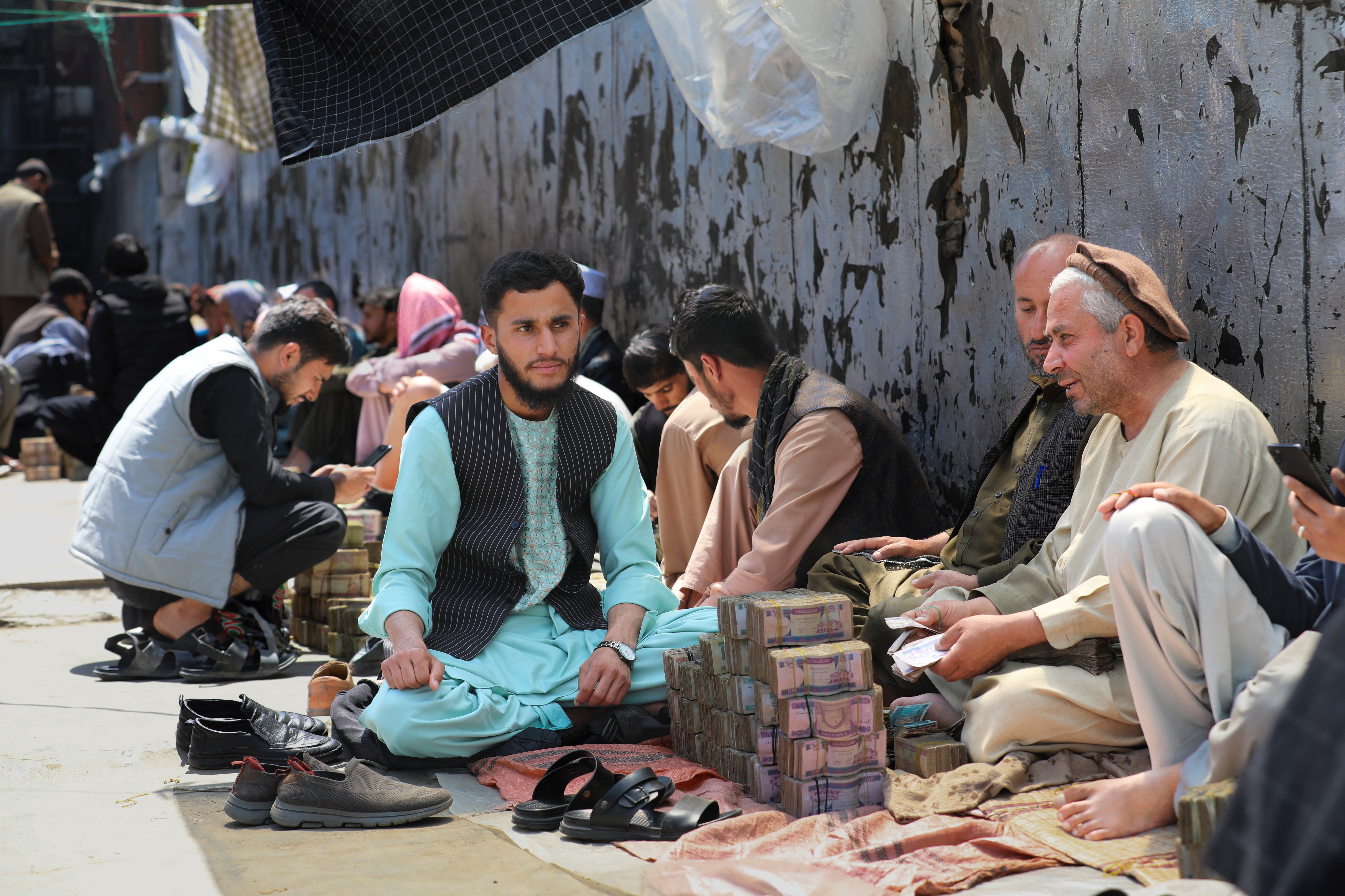 Afghan money changers wait for customers at a currency exchange market in Kabul