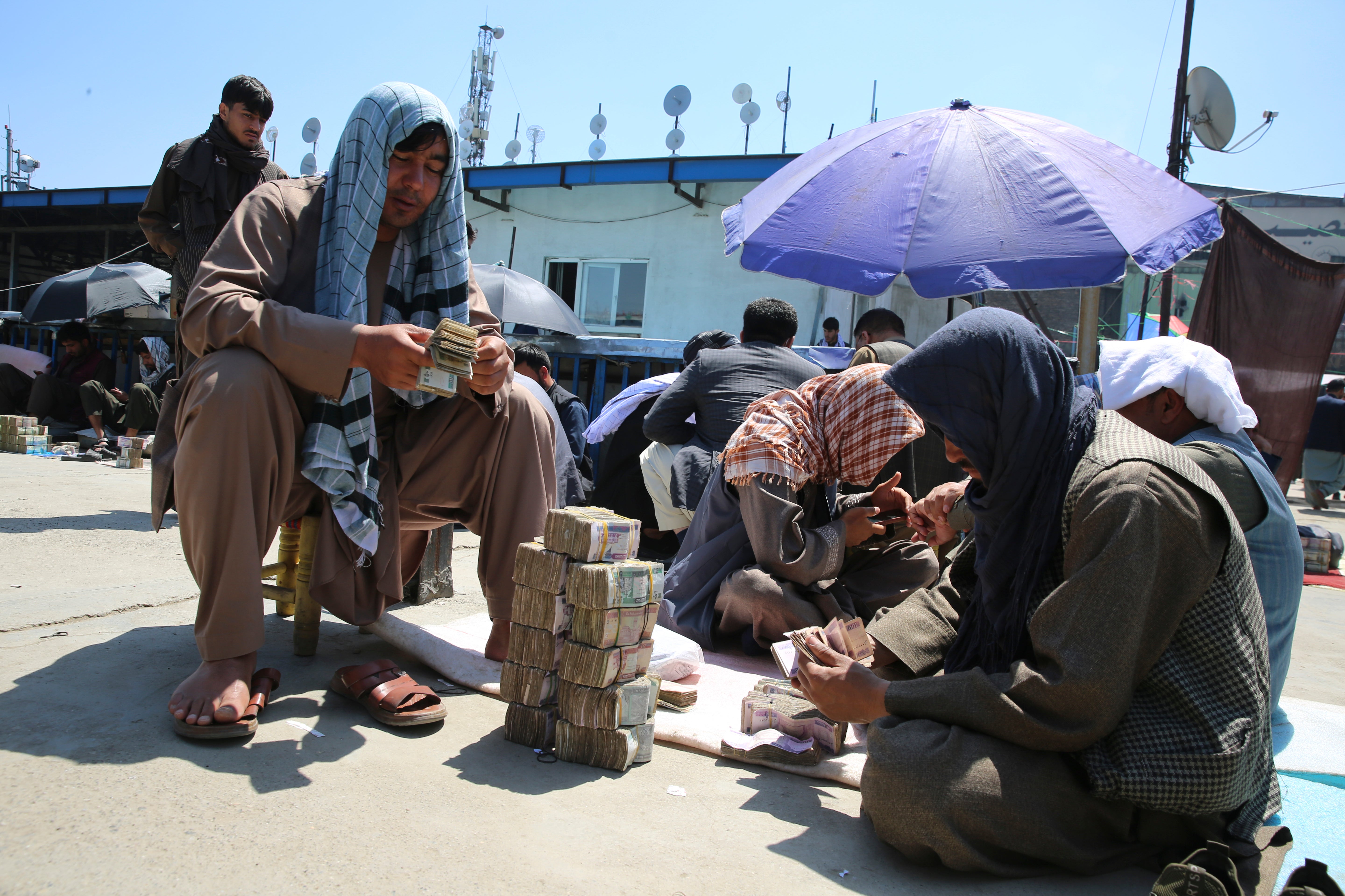 Afghan money changers wait for customers at a currency exchange market in Kabul, Afghanistan, Monday, April 22, 2024