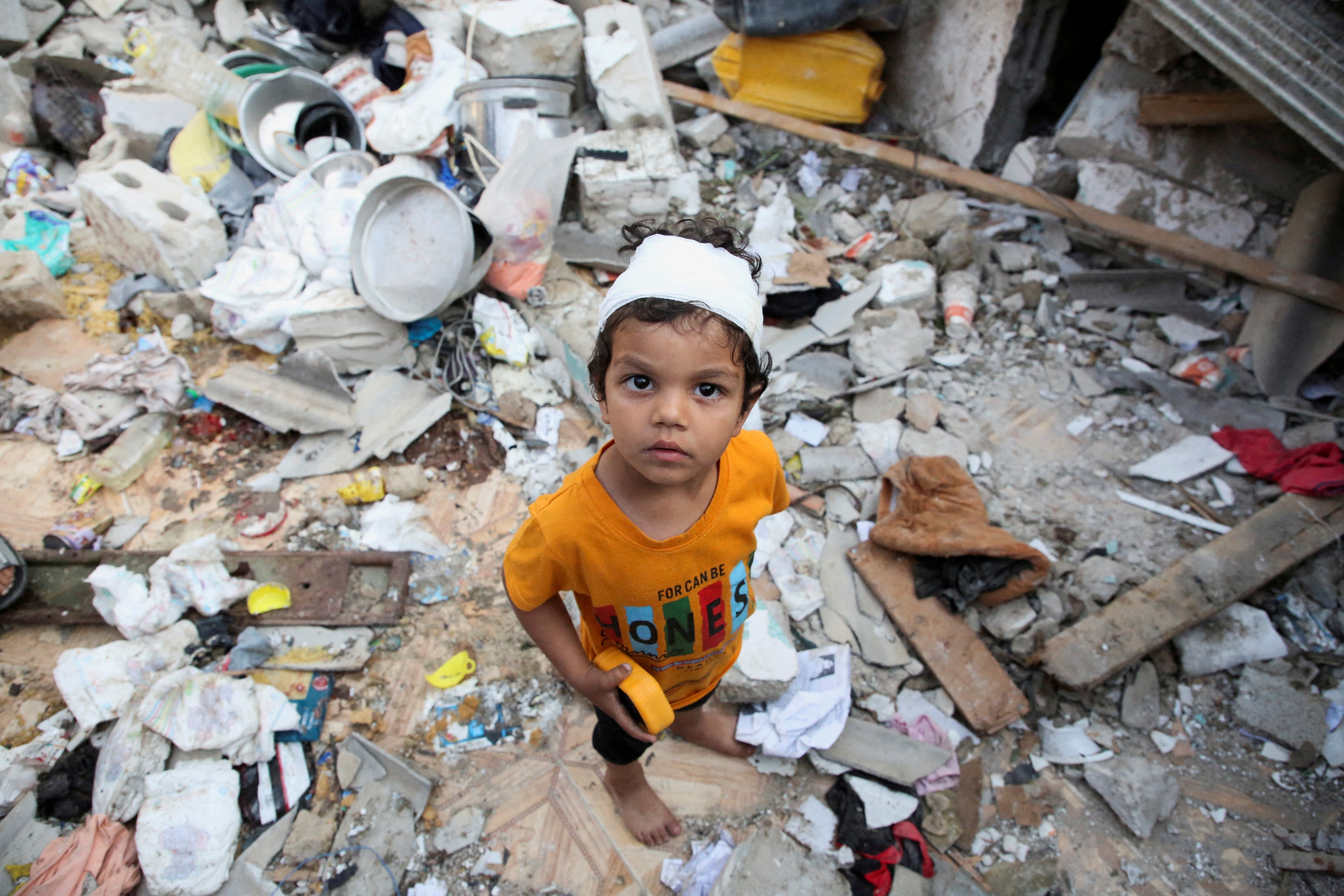 A wounded Palestinian boy reacts at the site of an Israeli strike on a house in Rafah