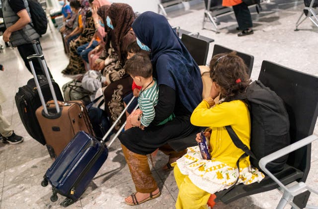 <p>Afgan refugees wait to be processed after arriving on an evacuation flight from Afghanistan, at Heathrow Airport, London in 2021 </p>