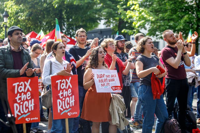 <p>Demonstrators with ‘Tax the rich!’ placards in Brussels, Belgium, on International Workers’ Day 2024</p>