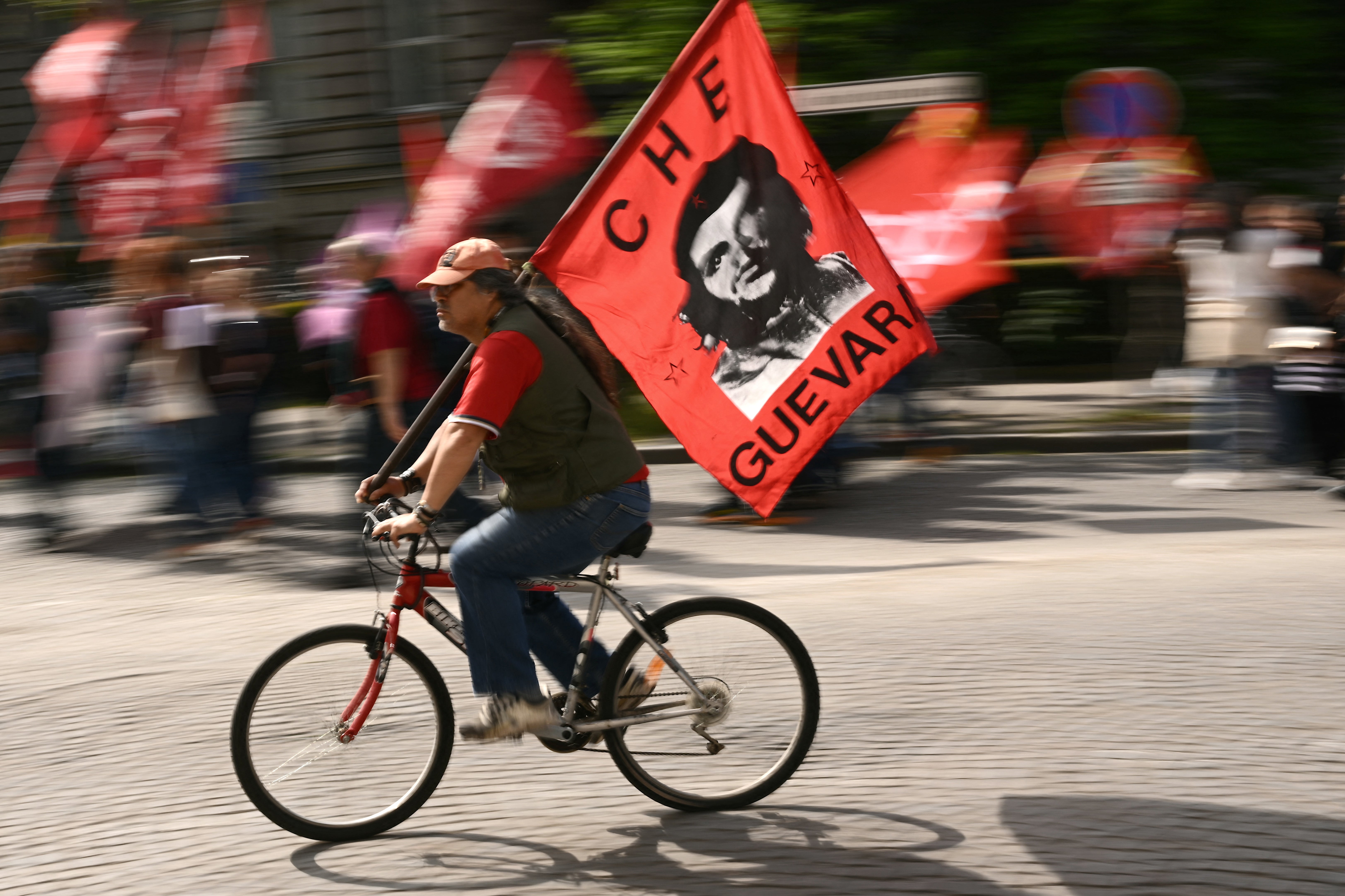 A protester on a bicycle waving a flag depicting Argentinian revolutionary Che Guevara during an International Workers’ Day demonstration in Strasbourg, France, on 1 May 2024
