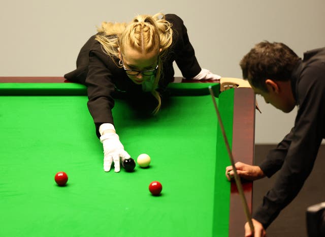 <p>Ronnie O’Sullivan keeps a close eye as Desislava Bozhilova re-spots the black</p>