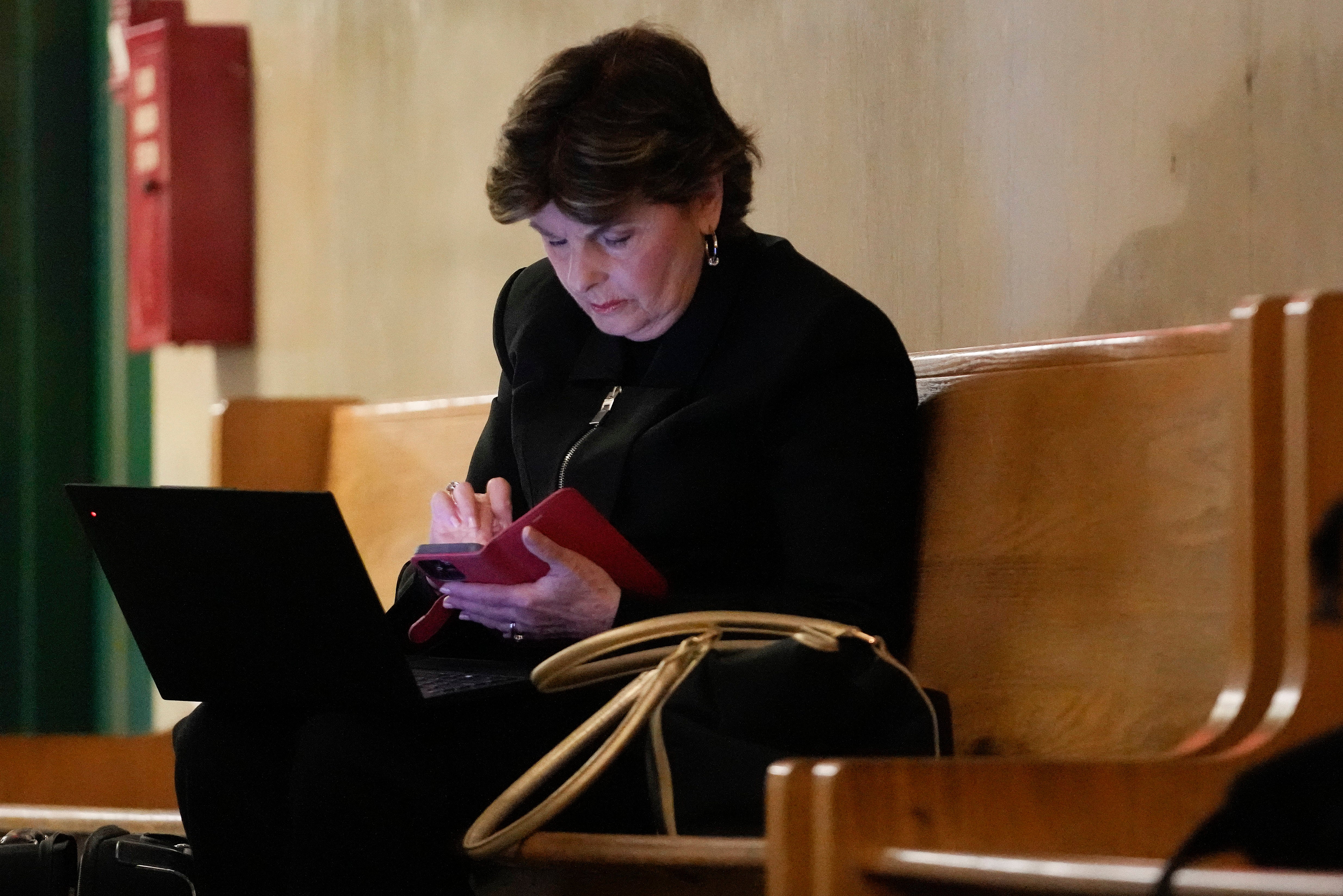 Gloria Allred works on her laptop outside a Manhattan criminal courtroom in May when Harvey Weinstein was due back in court