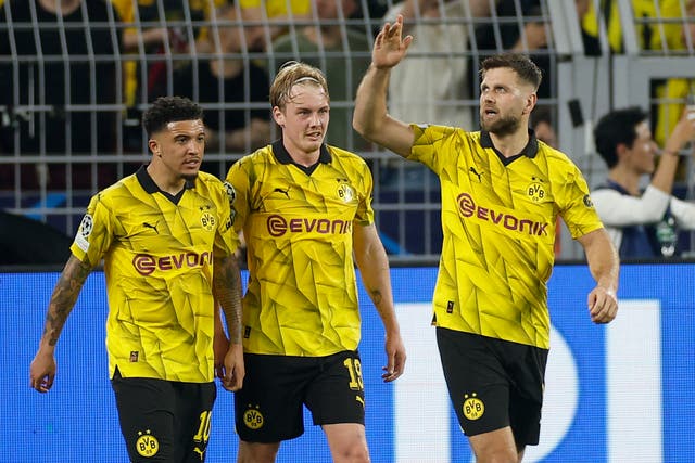 <p>Jadon Sancho, left, Julian Brandt, centre, and Niclas Fullkrug, right, celebrate the win for Dortmund </p>