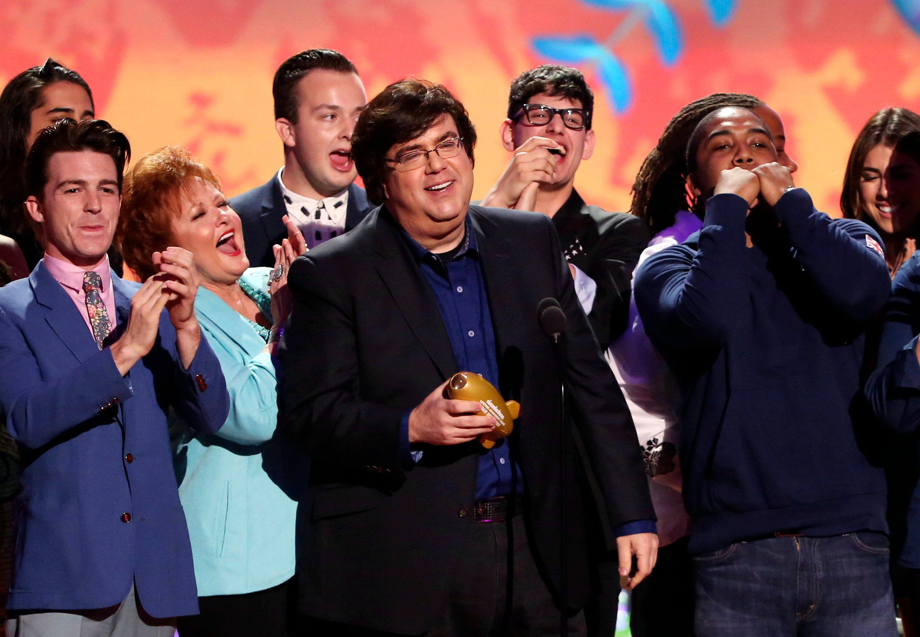 Dan Schneider, center, accepts an award in Los Angeles. He exited Nickelodeon in 2018 after an investigation determined he committed verbal abuse on set