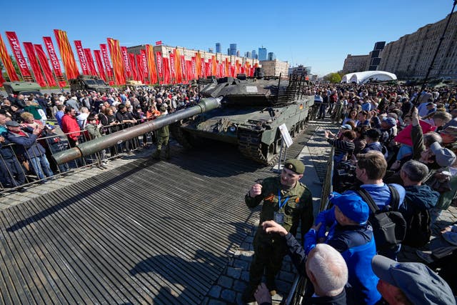 <p>Visitors look at a German Leopard tank captured by Russian troops during the fighting in Ukraine and displayed in Moscow</p>