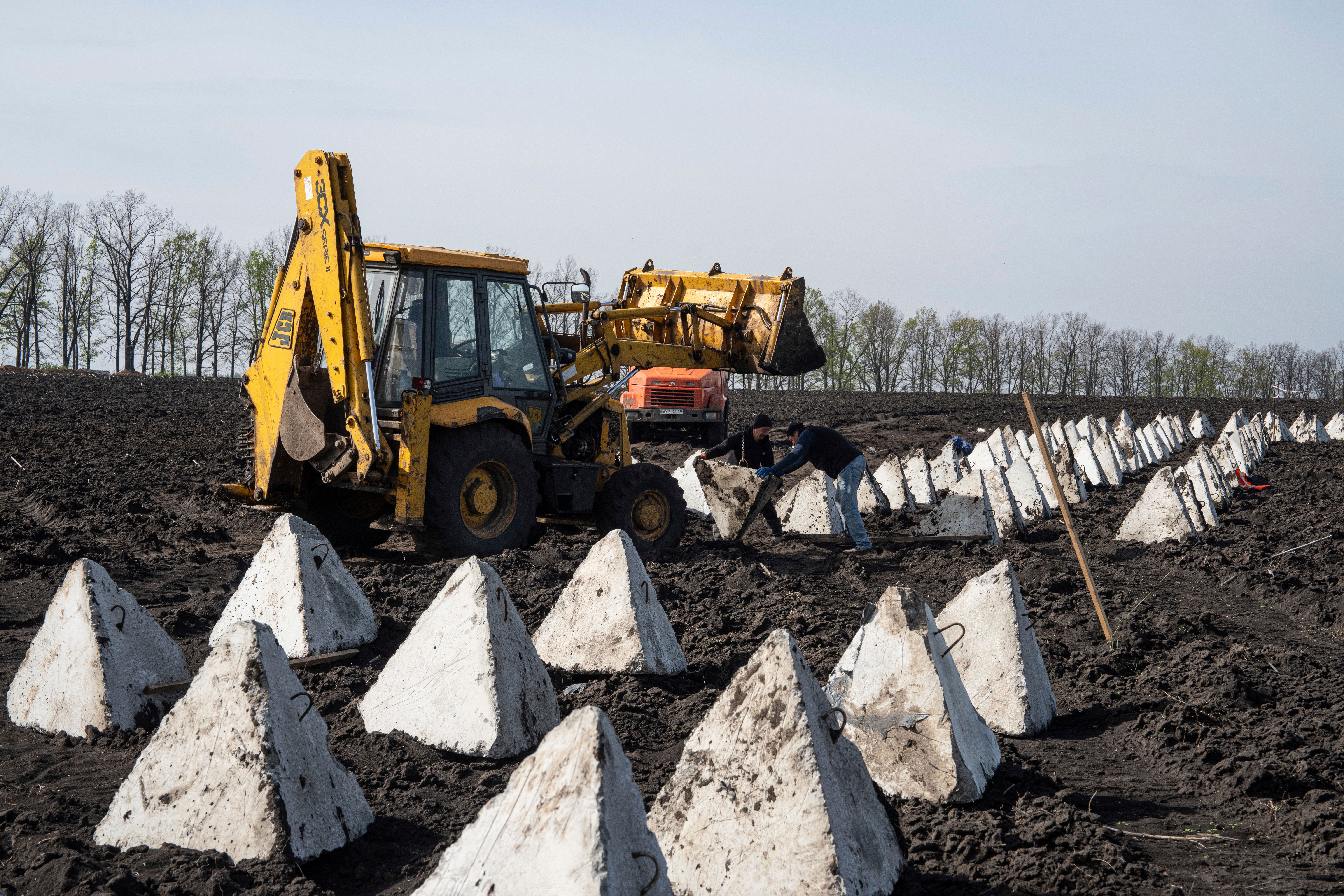 Ukrainian workers install anti-tank ‘dragon teeth’ as they construct new defensive positions in Kharkiv region