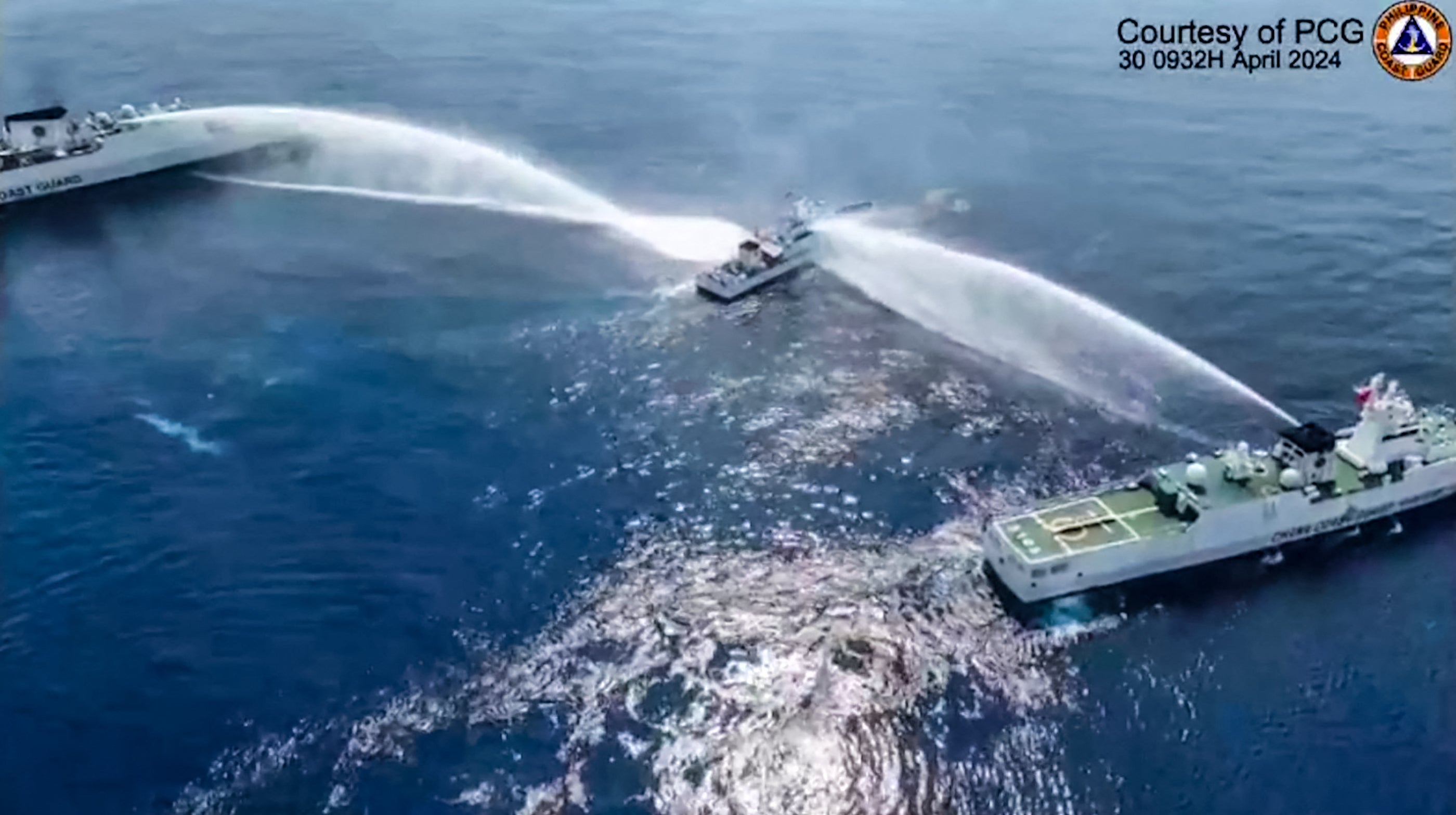 <p>This frame grab from handout video footage taken and released on 30 April 2024 by the Philippine Coast Guard (PCG) shows the Philippine Coast Guard ship BRP Bagacay (C) being hit by water cannon </p>