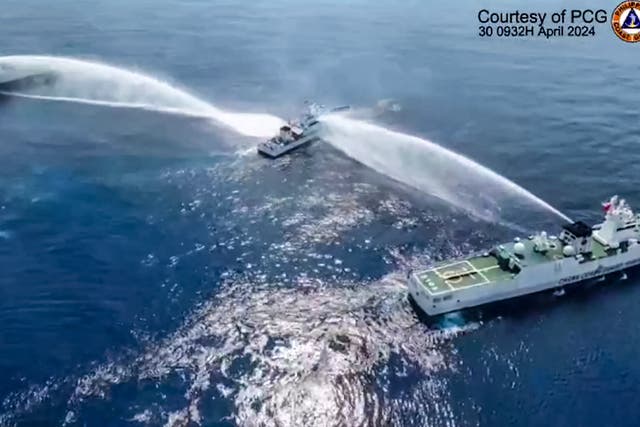 <p>This frame grab from handout video footage taken and released on 30 April 2024 by the Philippine Coast Guard (PCG) shows the Philippine Coast Guard ship BRP Bagacay (C) being hit by water cannon </p>