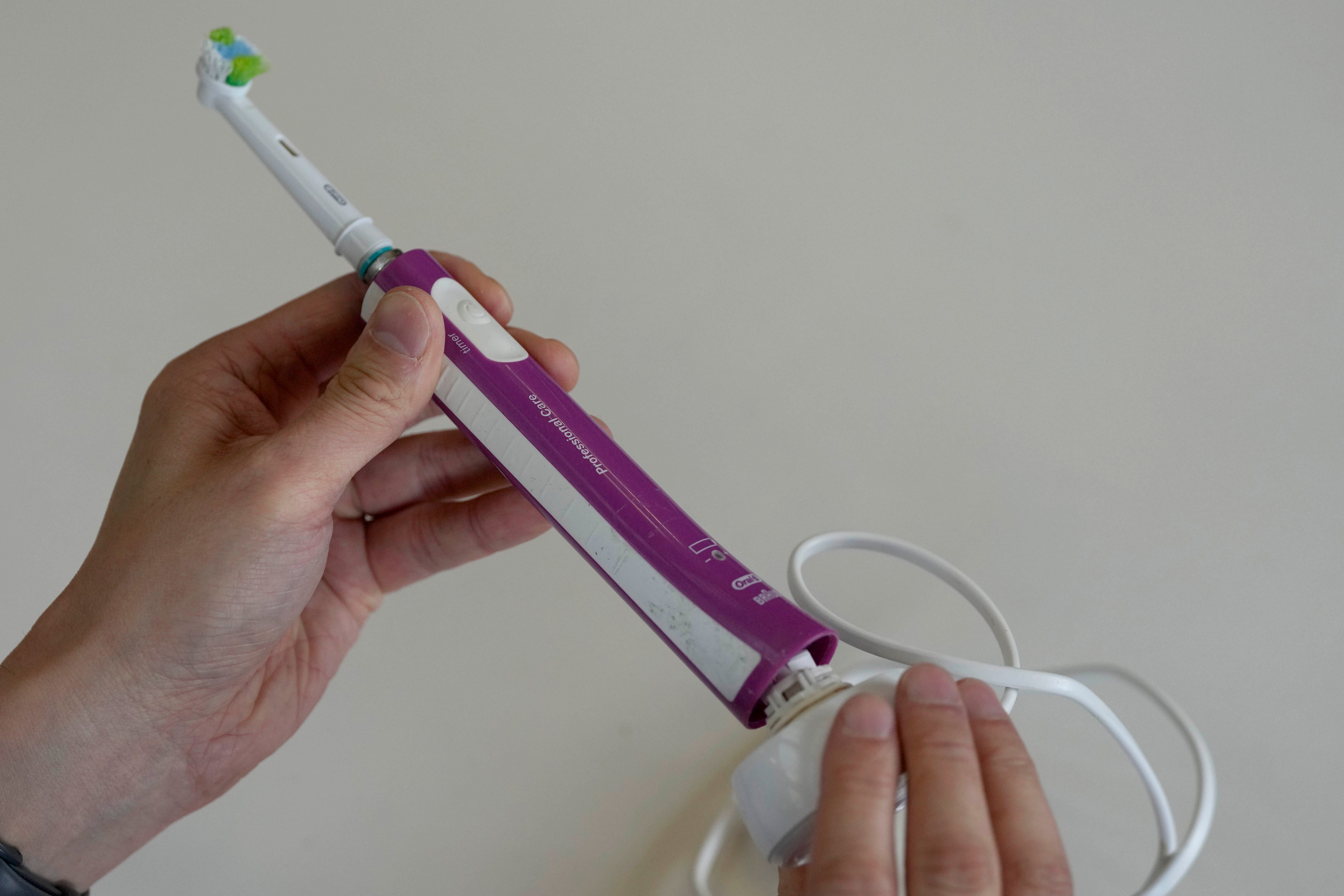 Dismantling an electric toothbrush by twisting the docking station in its port
