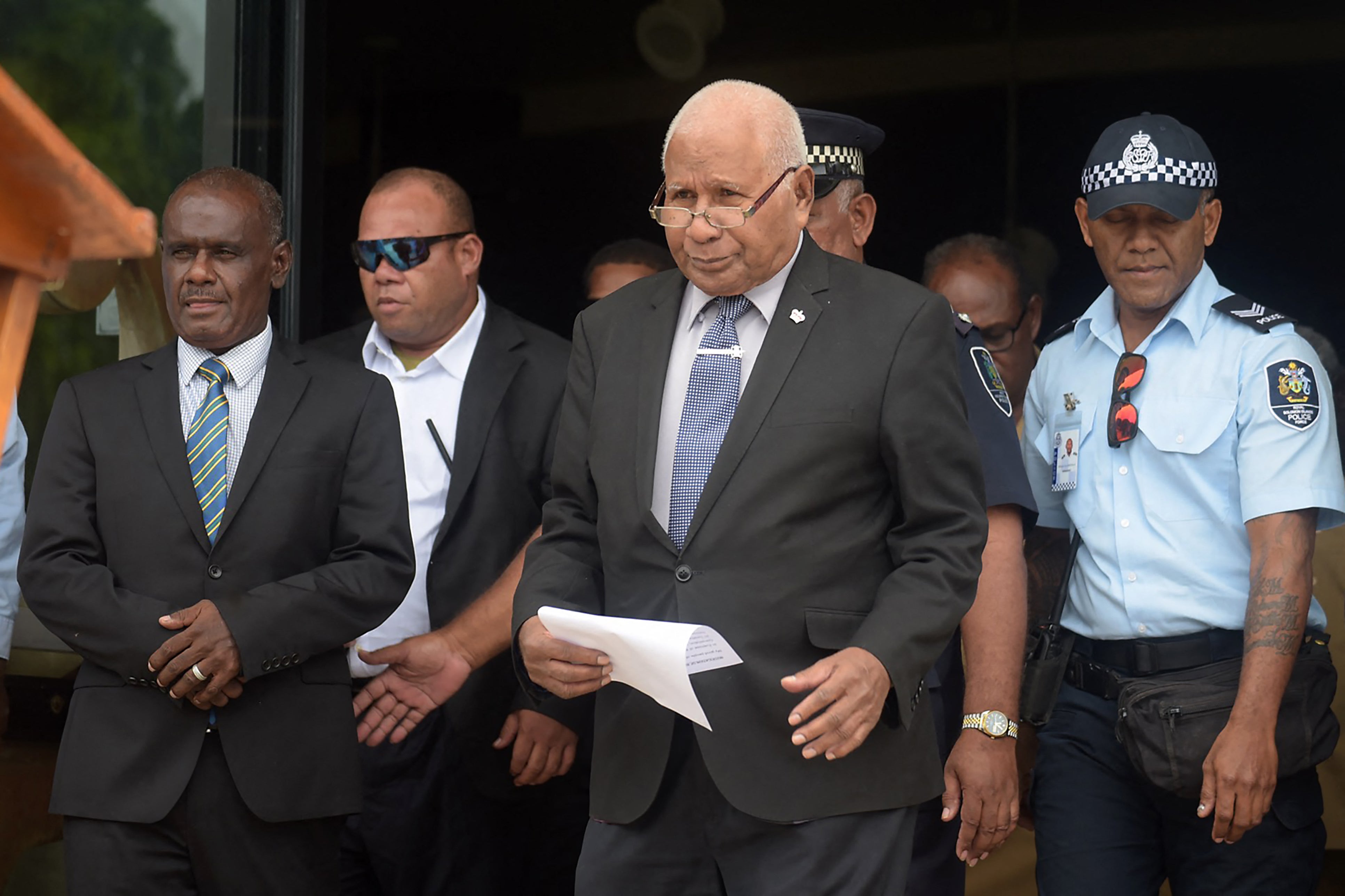 Solomon Islands' newly elected Prime Minister Jeremiah Manele (L) and Governor-General David Vunagi come out of Parliament House