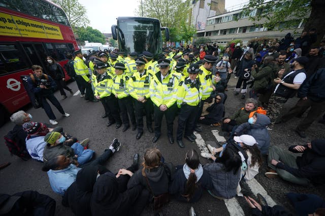 <p>Police with protesters who formed a blockade around a coach which is parked near the Best Western hotel in Peckham, south London, to prevent the removal of migrants from the temporary accommodation (Yui Mok/PA)</p>