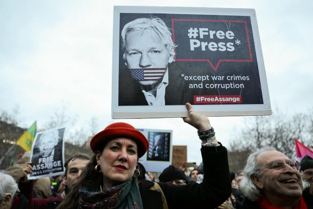 <p>A woman holds a sign demanding Wikileaks founder Julian Assange’s release from prison during a rally in Paris on 20 February 2024</p>