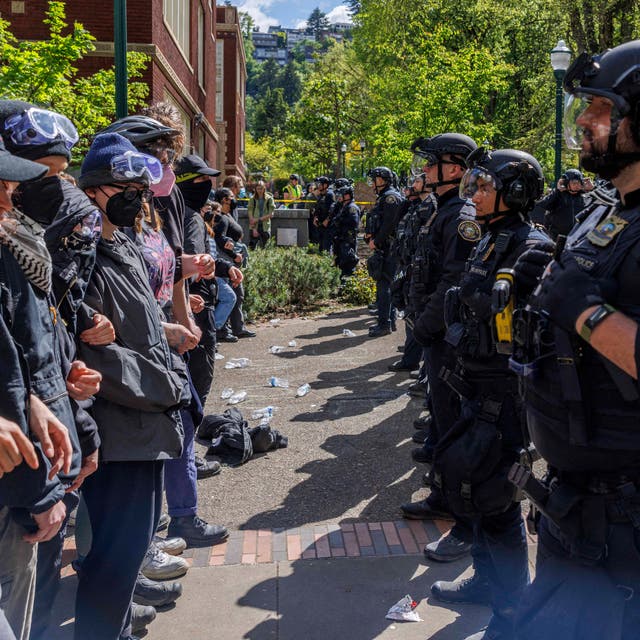 <p>Pro-Palestinian students and activists face police officers after protesters were evicted from the library on campus earlier in the day at Portland State University in Portland, Oregon on May 2, 2024</p>
