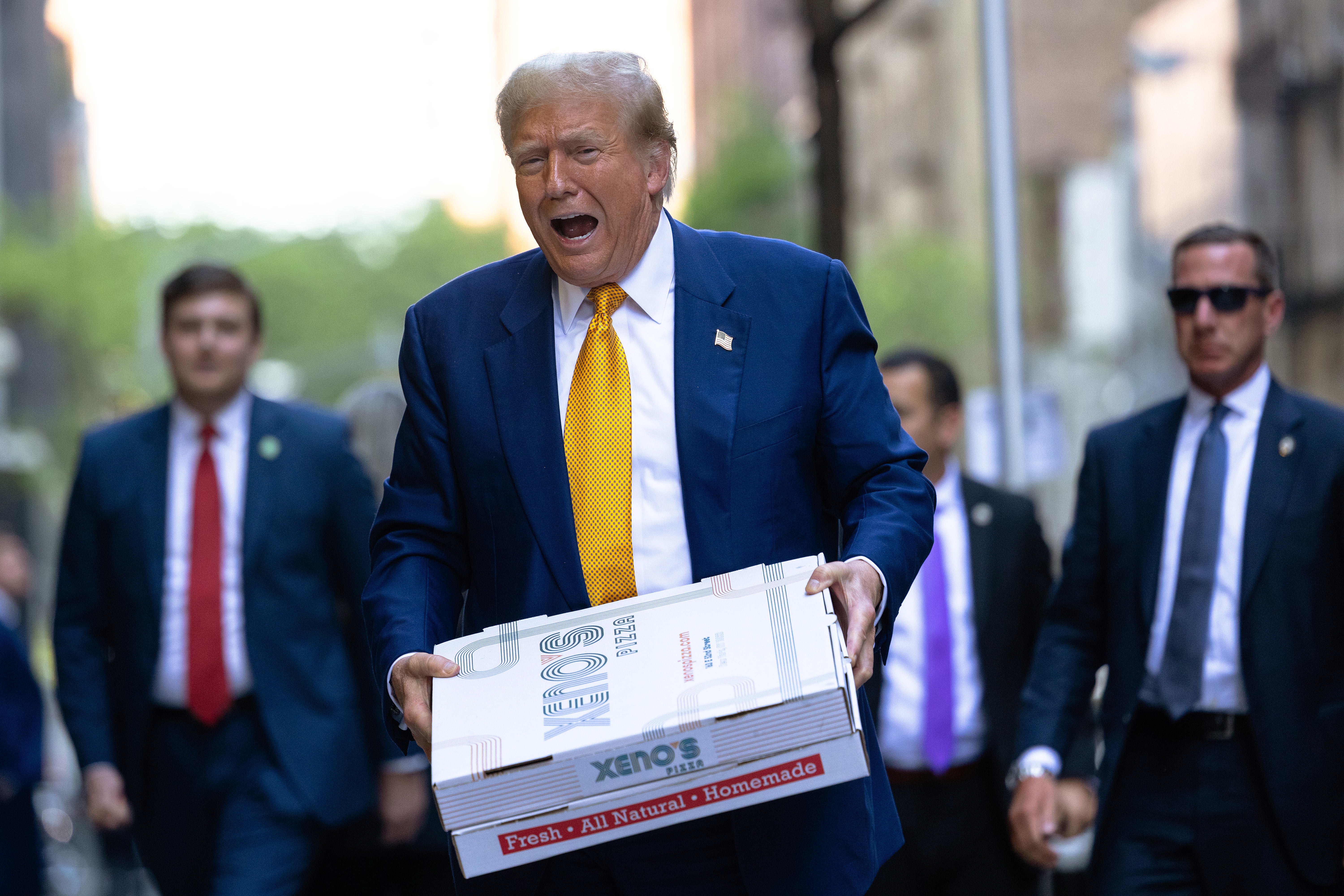 Donald Trump carries boxes of pizza for the FDNY Engine 2, Battalion 8 firehouse on May 02, 2024 in New York City