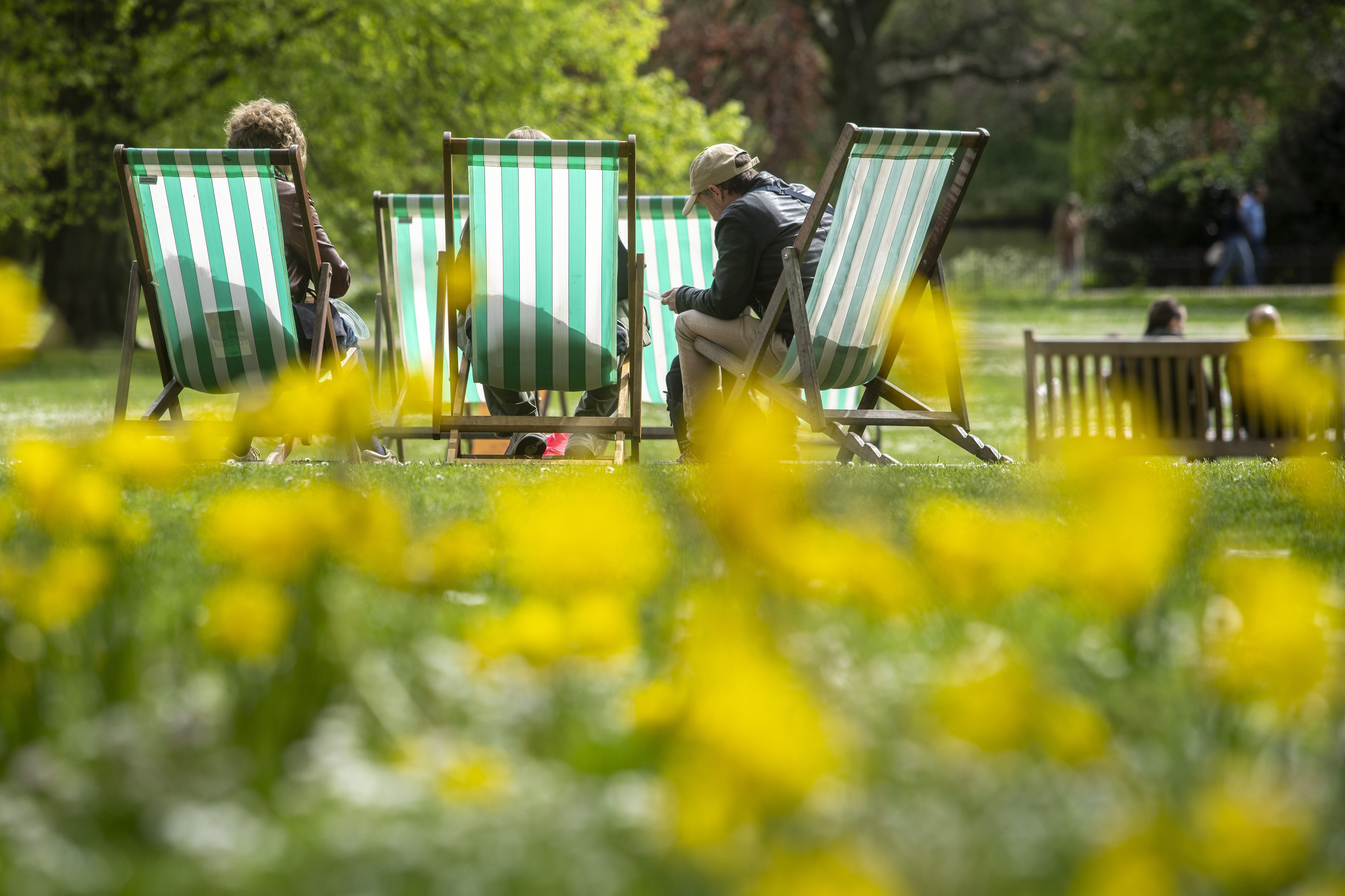 People make use of deckchairs at St James’s Park in central London