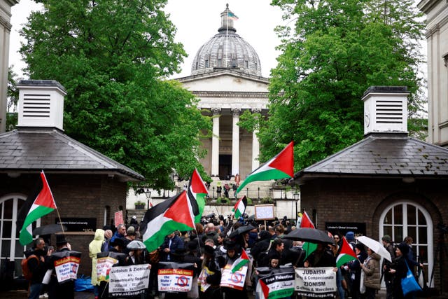 <p>People hold placards and wave Palestinian flags as they take part in demonstration in support to Palestinian people at University College London (UCL) main entrance</p>