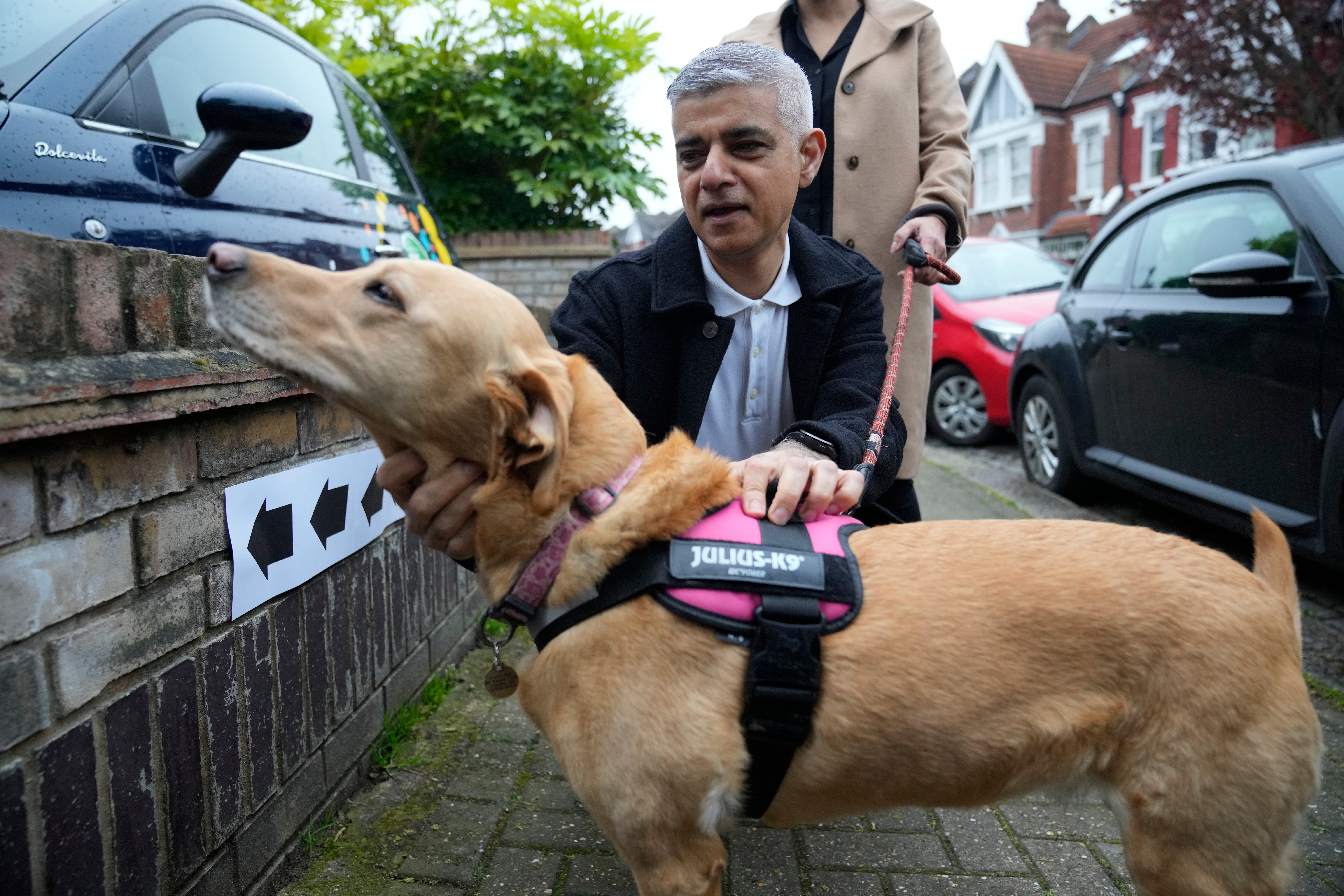 Sadiq Khan pats his dog Luna as they pose for the media he arrives to vote in London last Thursday