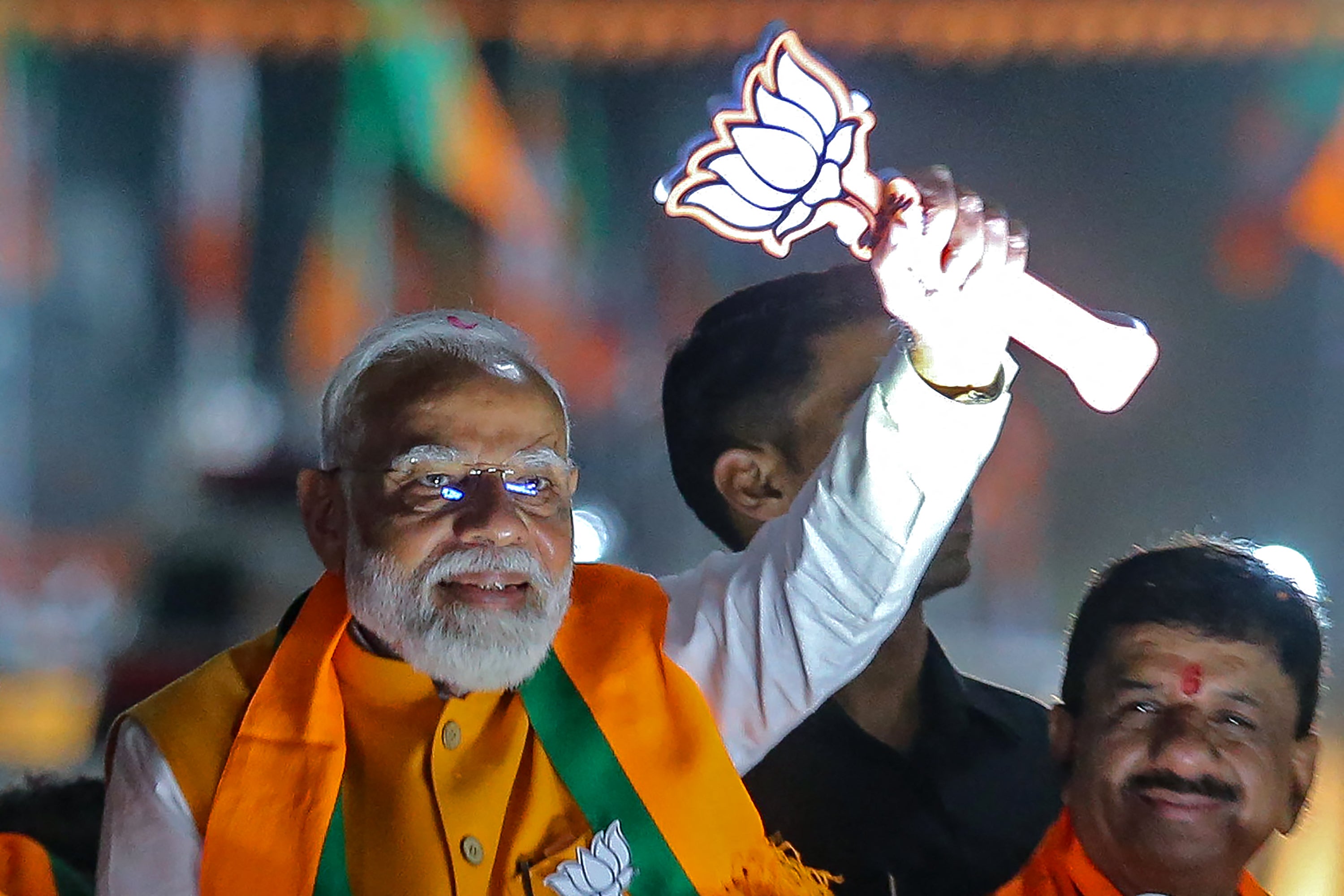 Narendra Modi greets supporters during a campaign roadshow in Bhopal on 24 April 2024