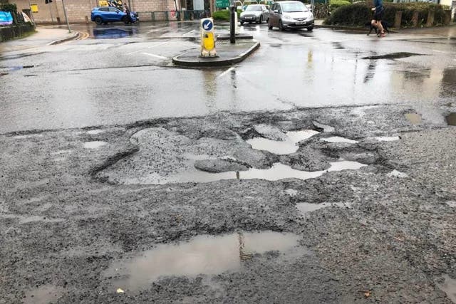 <p>A large pothole in Totnes, Devon, became a listed tourist attraction on TripAdvisor</p>